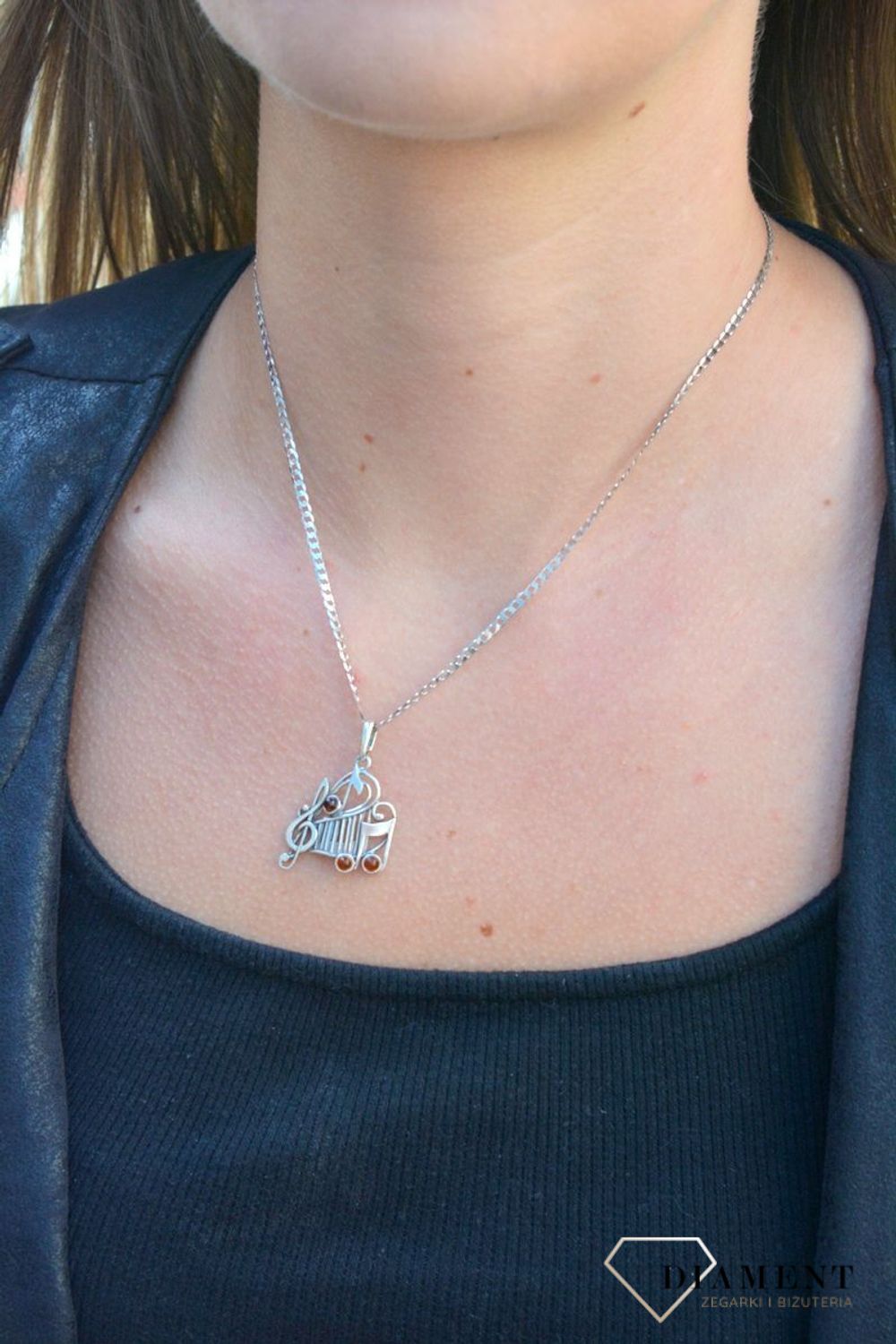 Zawieszka srebrna w kształcie nutek z bursztynem  DIA-ZAW-7130-925. Bursztyn wprawiono w najwyższej jakości srebro o próbie 925, kruszec od wielu setek lat symbolizujący głębię emocjonalną, duchowość i żeńską energię.jpg