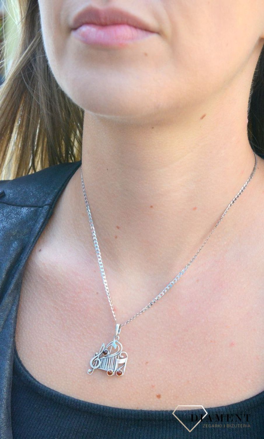 Zawieszka srebrna w kształcie nutek z bursztynem  DIA-ZAW-7130-925. Bursztyn wprawiono w najwyższej jakości srebro o próbie 925, kruszec od wielu setek lat symbolizujący głębię emocjonalną, duchowość i żeńską energię.jpg