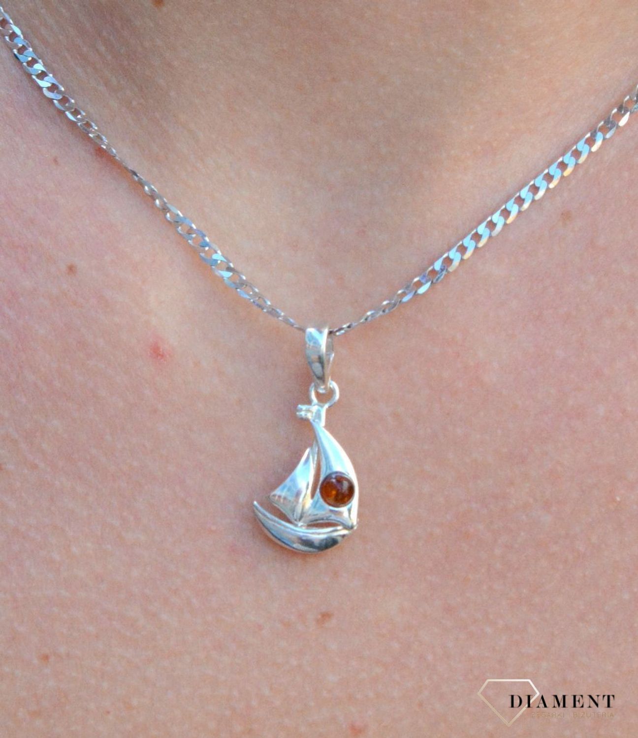 Zawieszka srebrna łódka z bursztynem DIA-ZAW-7133-925. Bursztyn wprawiono w najwyższej jakości srebro o próbie 925, kruszec od wielu setek lat symbolizujący głębię emocjonalną, duchowość i żeńską energię..jpg