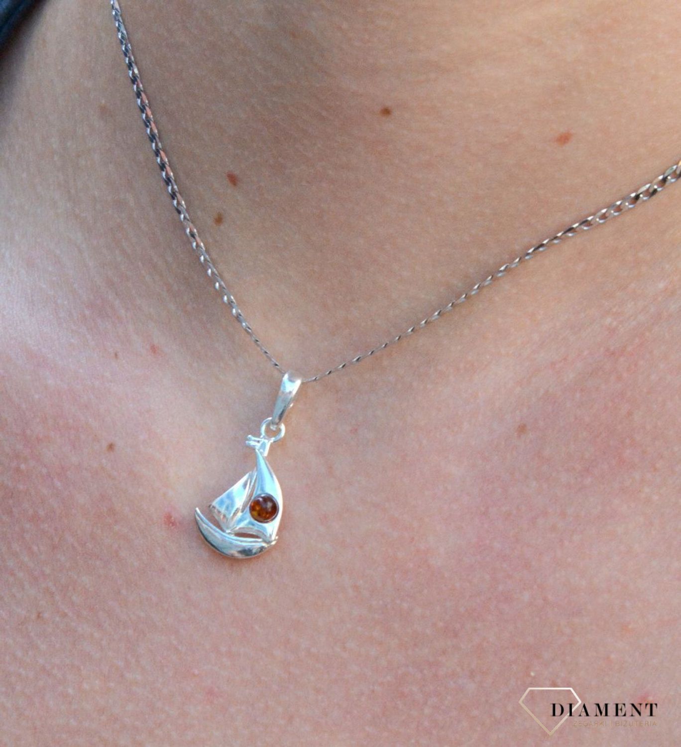 Zawieszka srebrna łódka z bursztynem DIA-ZAW-7133-925. Bursztyn wprawiono w najwyższej jakości srebro o próbie 925, kruszec od wielu setek lat symbolizujący głębię emocjonalną, duchowość i żeńską energię..jpg