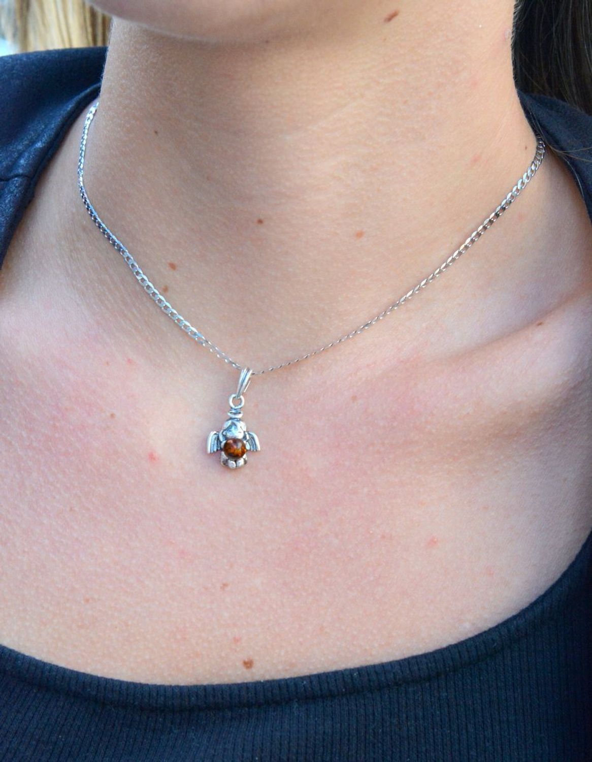 Srebrna zawieszka anioł z bursztynem DIA-ZAW-7134-925.  Elegancka zawieszka w kształcie aniołka z bursztynem. Zawieszka została wykonana z najwyższej jakości srebra próby 925.jpg