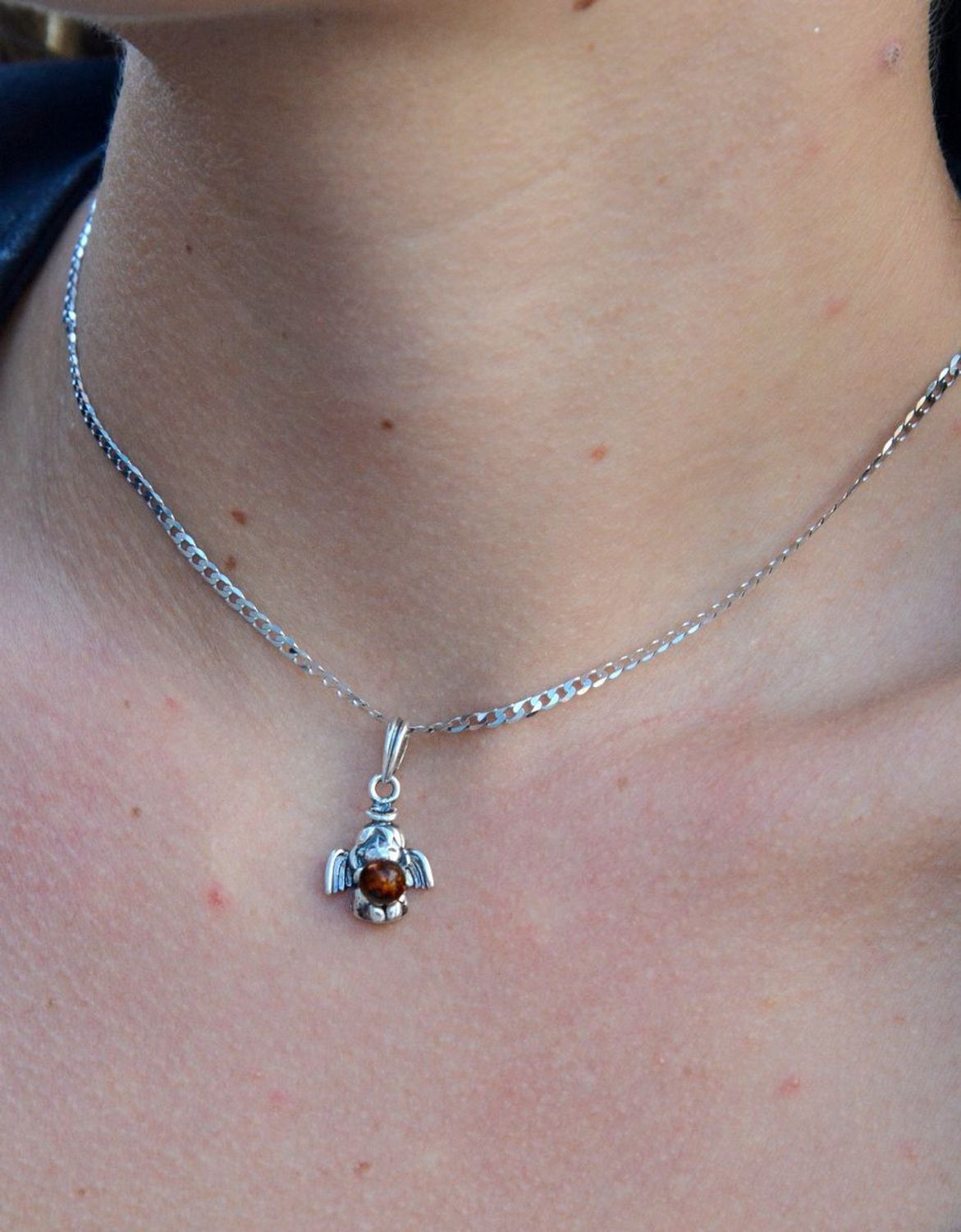 Srebrna zawieszka anioł z bursztynem DIA-ZAW-7134-925.  Elegancka zawieszka w kształcie aniołka z bursztynem. Zawieszka została wykonana z najwyższej jakości srebra próby 925.jpg