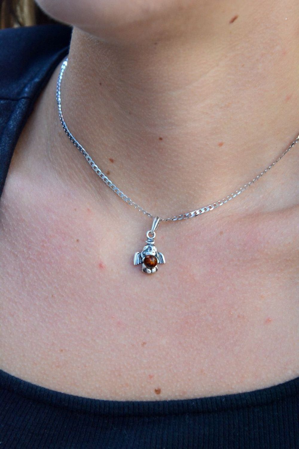 Srebrna zawieszka anioł z bursztynem DIA-ZAW-7134-925.  Elegancka zawieszka w kształcie aniołka z bursztynem. Zawieszka została wykonana z najwyższej jakości srebra próby 925.jpg