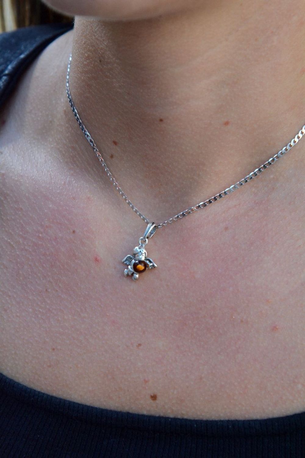 Zawieszka srebrna w kształcie aniołka z bursztynem DIA-ZAW-7135-925.  Bursztyn wprawiono w najwyższej jakości srebro o próbie 925, kruszec od wielu setek lat symbolizujący głębię emocjonalną, duchowość i żeńską energię.jpg