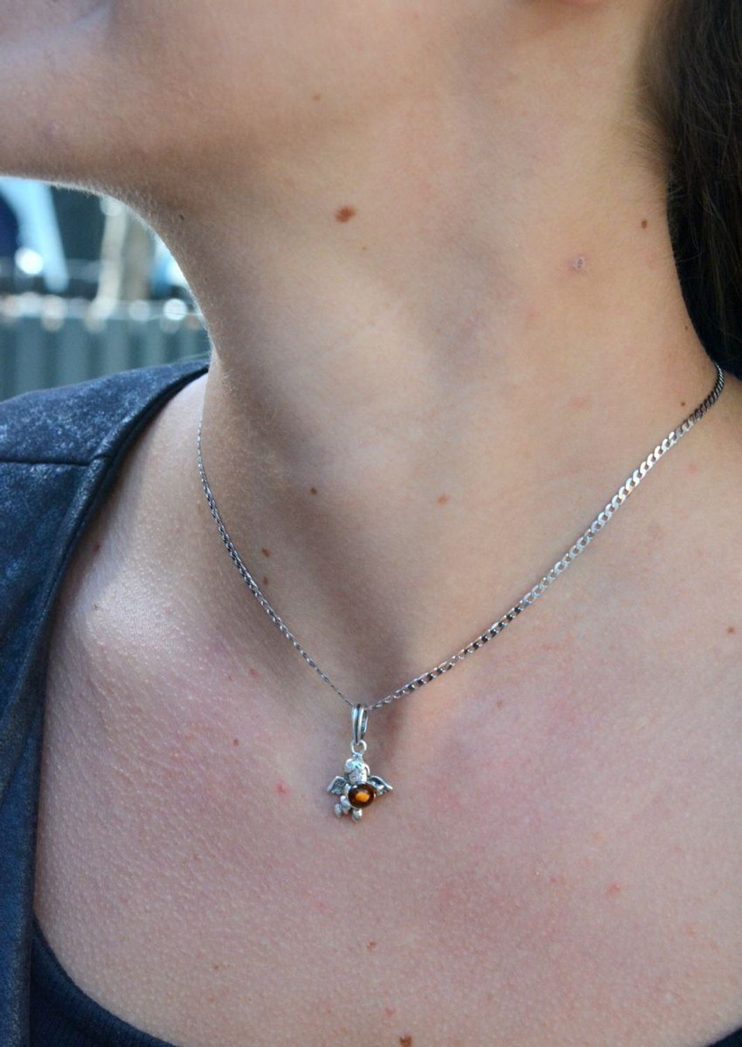 Zawieszka srebrna w kształcie aniołka z bursztynem DIA-ZAW-7135-925.  Bursztyn wprawiono w najwyższej jakości srebro o próbie 925, kruszec od wielu setek lat symbolizujący głębię emocjonalną, duchowość i żeńską energię.jpg