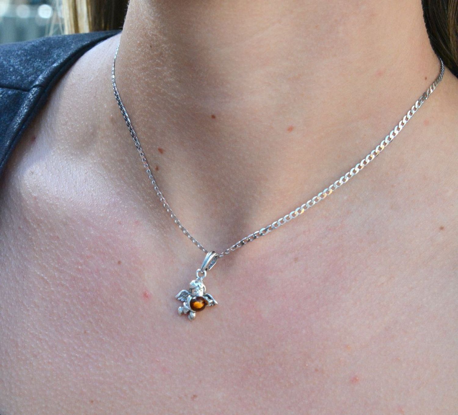 Zawieszka srebrna w kształcie aniołka z bursztynem DIA-ZAW-7135-925.  Bursztyn wprawiono w najwyższej jakości srebro o próbie 925, kruszec od wielu setek lat symbolizujący głębię emocjonalną, duchowość i żeńską energię.jpg