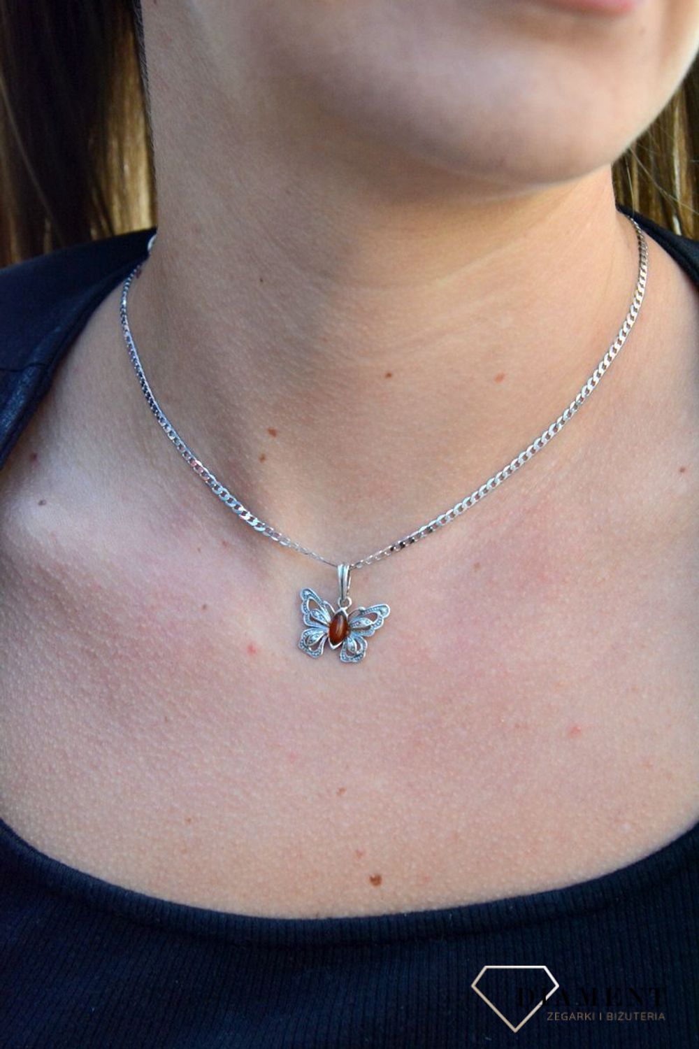 Zawieszka w kształcie motyla z bursztynem  DIA-ZAW-7137-925.  Bursztyn wprawiono w najwyższej jakości srebro o próbie 925, kruszec od wielu setek lat symbolizujący głębię emocjonalną, duchowość i żeńską energię.jpg