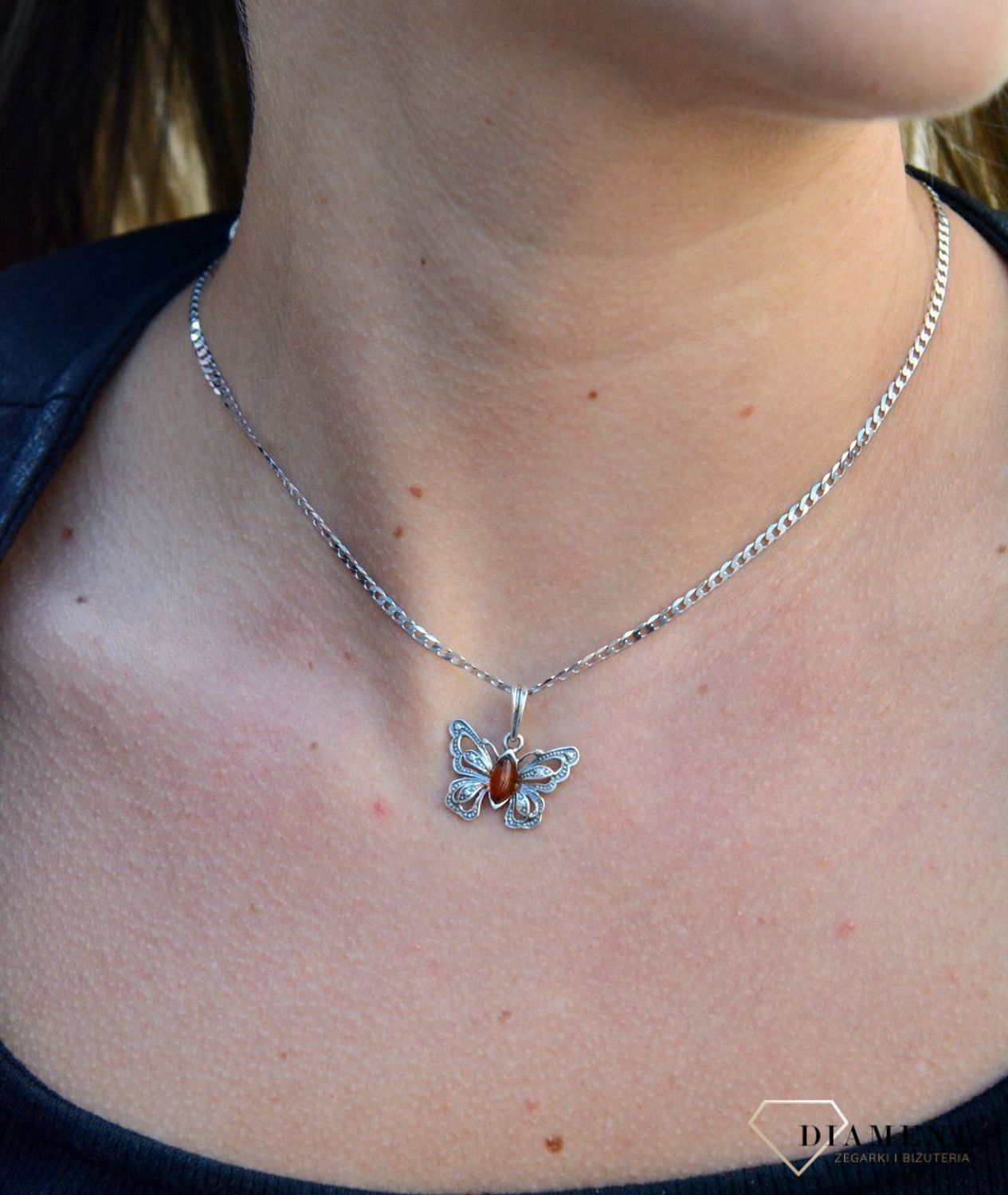 Zawieszka w kształcie motyla z bursztynem  DIA-ZAW-7137-925.  Bursztyn wprawiono w najwyższej jakości srebro o próbie 925, kruszec od wielu setek lat symbolizujący głębię emocjonalną, duchowość i żeńską energię.jpg