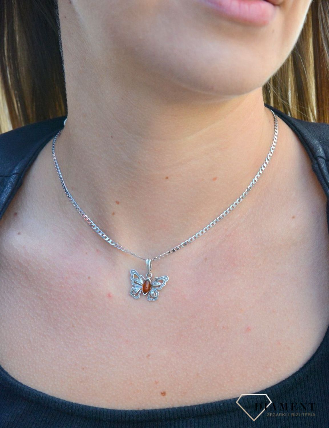 Zawieszka w kształcie motyla z bursztynem  DIA-ZAW-7137-925.  Bursztyn wprawiono w najwyższej jakości srebro o próbie 925, kruszec od wielu setek lat symbolizujący głębię emocjonalną, duchowość i żeńską energię.jpg