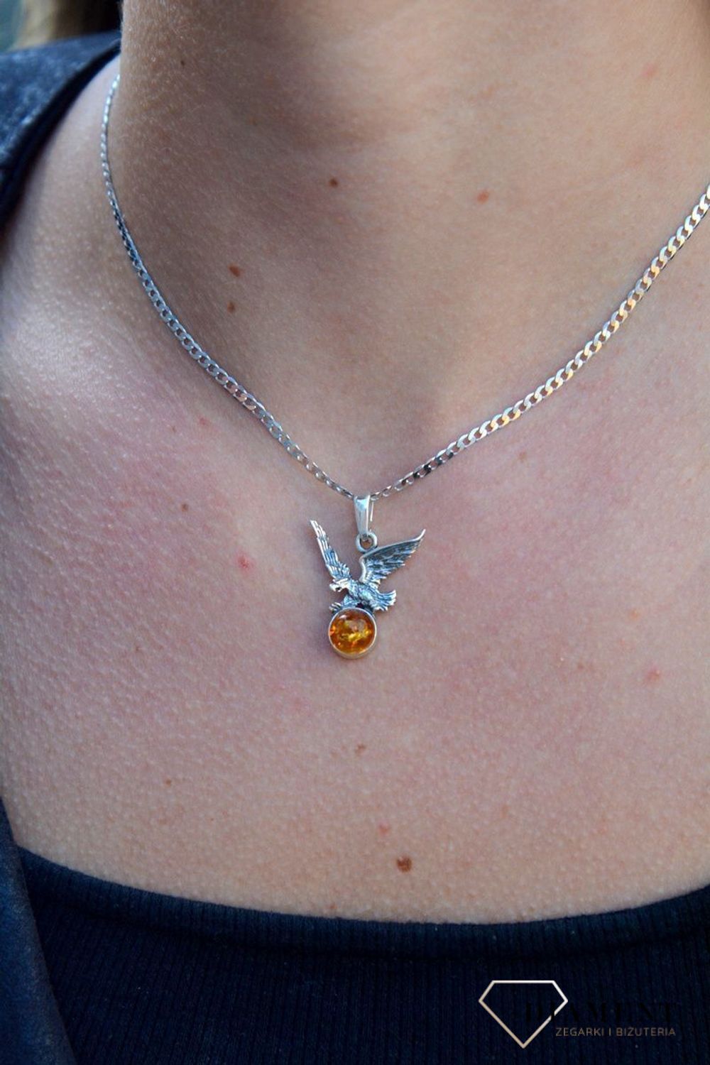 Zawieszka srebrna orzeł z bursztynem DIA-ZAW-7140-925. Bursztyn wprawiono w najwyższej jakości srebro o próbie 925, kruszec od wielu setek lat symbolizujący głębię emocjonalną, duchowość i żeńską energię.jpg