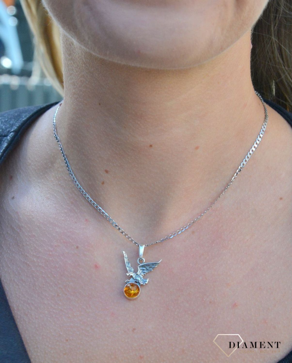Zawieszka srebrna orzeł z bursztynem DIA-ZAW-7140-925. Bursztyn wprawiono w najwyższej jakości srebro o próbie 925, kruszec od wielu setek lat symbolizujący głębię emocjonalną, duchowość i żeńską energię.jpg