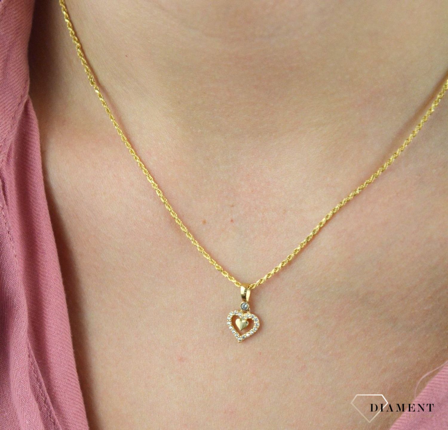Złota zawieszka 585 serce ozdobione cyrkonią DIA-ZAW-7846A-585. Romantyczny wzór, który nada uroku oraz kobiecości każdej stylizacji. Wyjątkowy wisiorek o ponadczasowym motywie zachwyca estetyczną formą wykonania oraz delikat.jpg