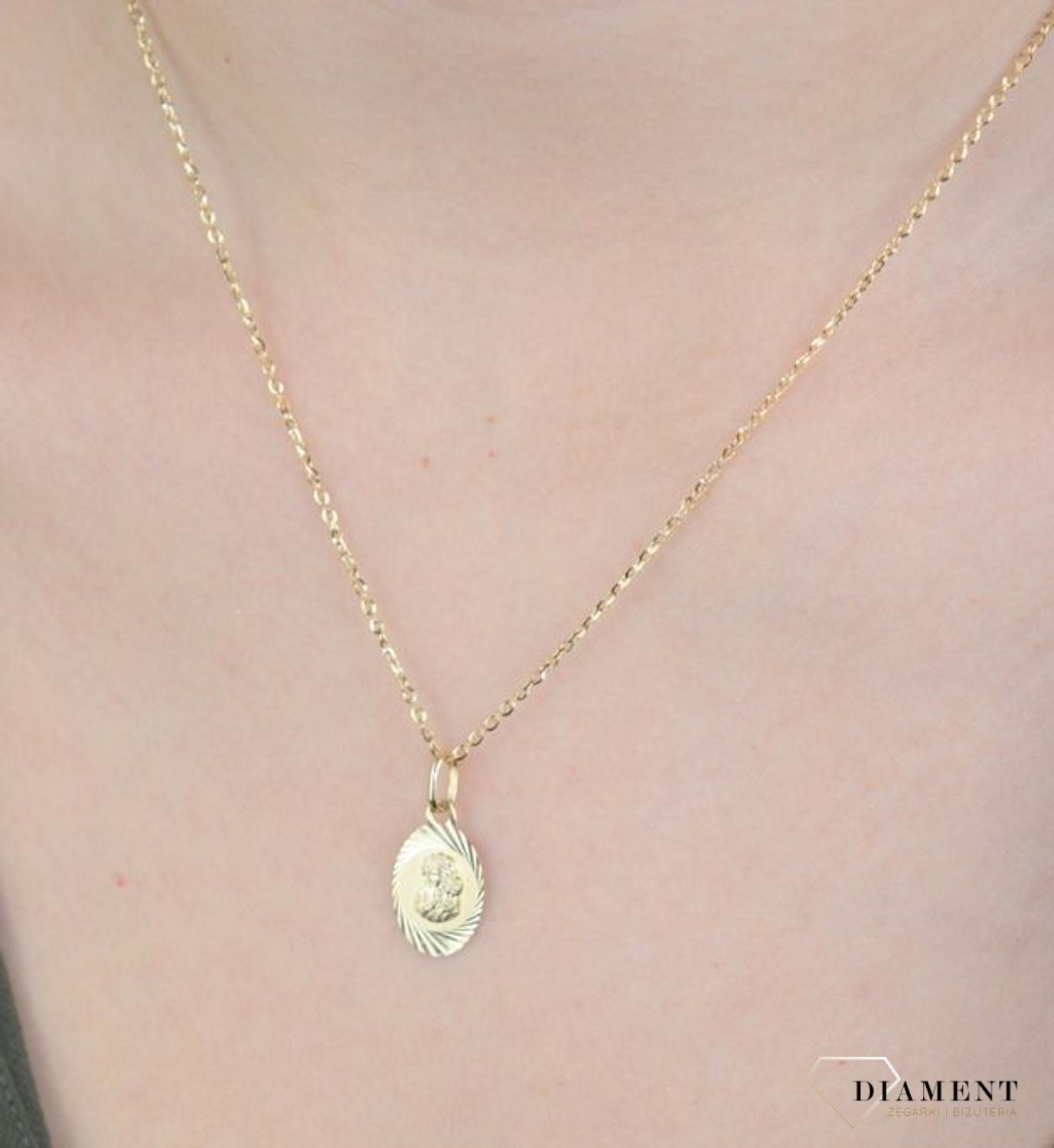Złota zawieszka medalik owalny 585 z Matką Boską DIA-ZAW-8584-585. Złota zawieszka medalik owalny 585 z Matką Boską.  Złoty medalik został wykonany z najwyższej jakości 14 – karatowego żółtego złota. Delikatny wisiorek Matki Boskiej.jpg