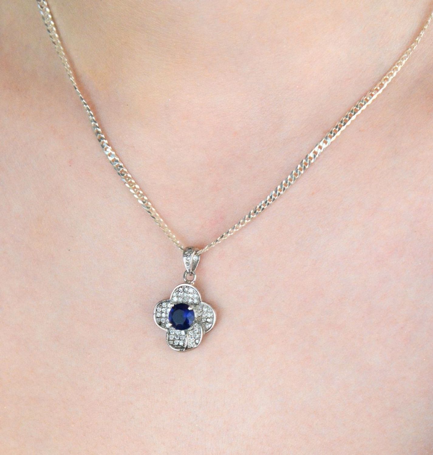 Srebrna zawieszka damska w kształcie kwiatka z lśniącymi cyrkoniami. Próba 925, długość 2,3 cm, szerokość 1,5 cm, waga 2,63 g – subtelna, kobieca i elegancka biżuteria.1.jpg