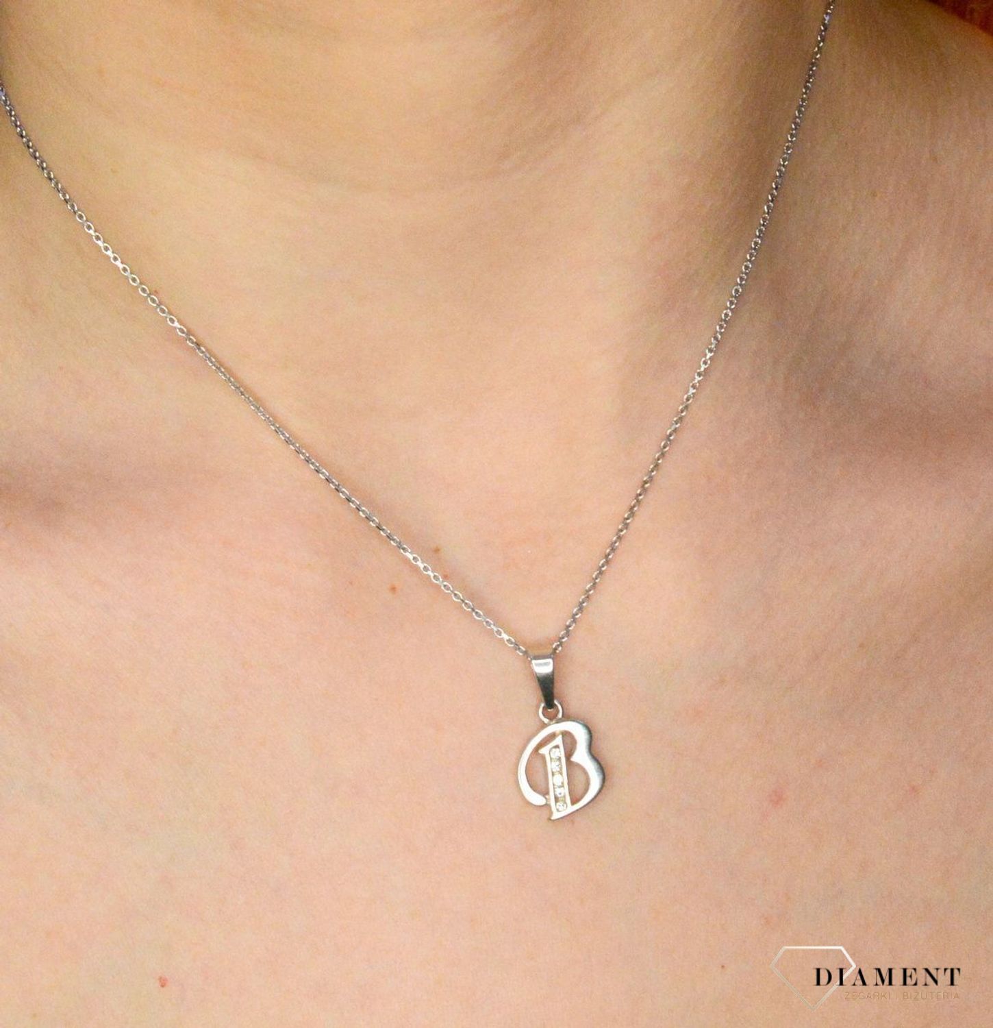 Srebrna zawieszka Literka B z cyrkonią DIA-ZAW-8748-B-925. Wisiorek został wykonany z wysokiej jakości srebra próby 925. Srebro to jeden z najpopularniejszych kruszców, ceniony przez kobiety na całym świecie i często wykorzyst.jpg