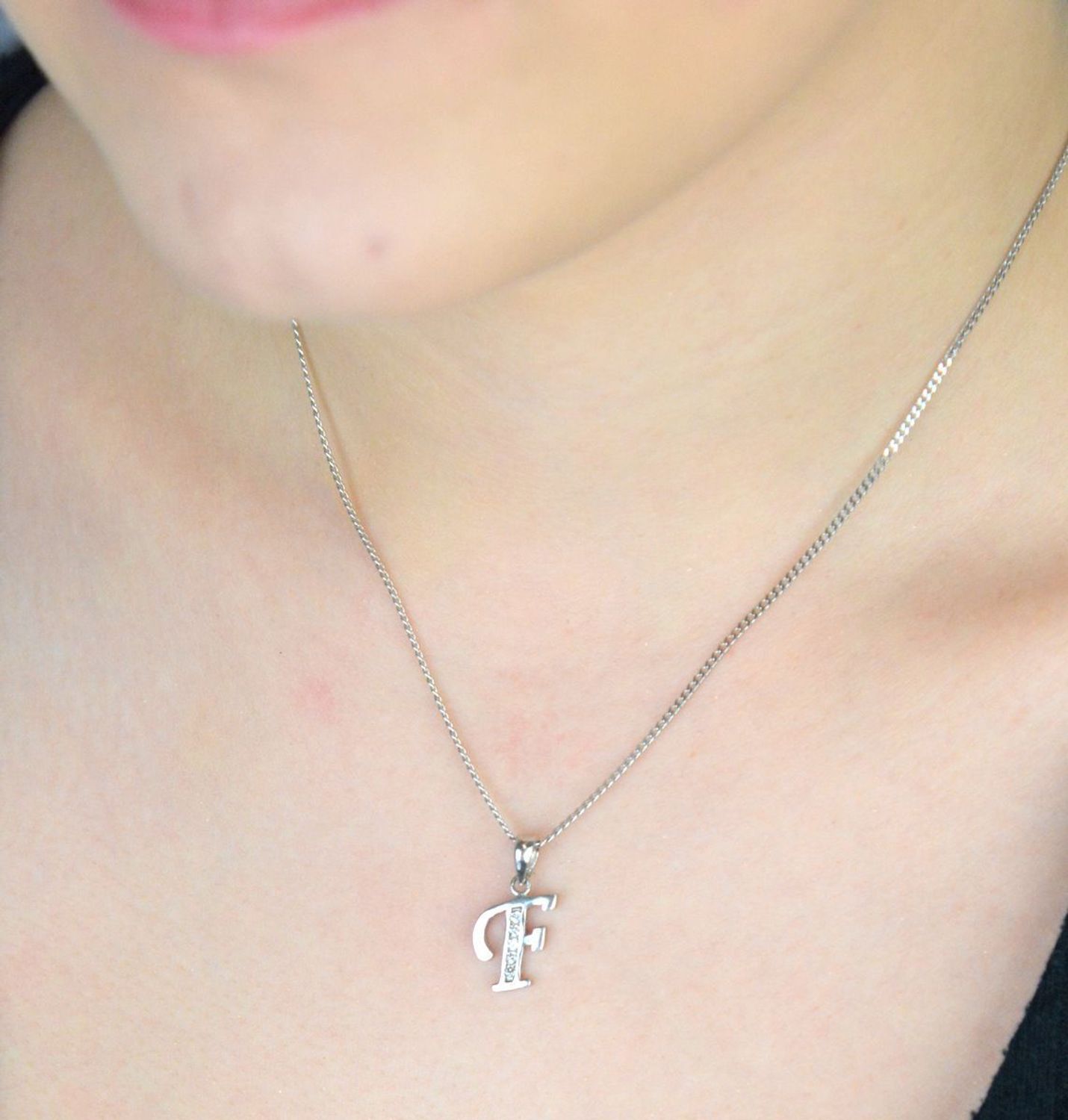 Elegancka srebrna zawieszka z literką F zdobioną cyrkoniami. Próba 925, waga 0,90 g, długość 2 cm, szerokość 0,9 cm. Subtelny blask i osobisty symbol w jednym..jpg