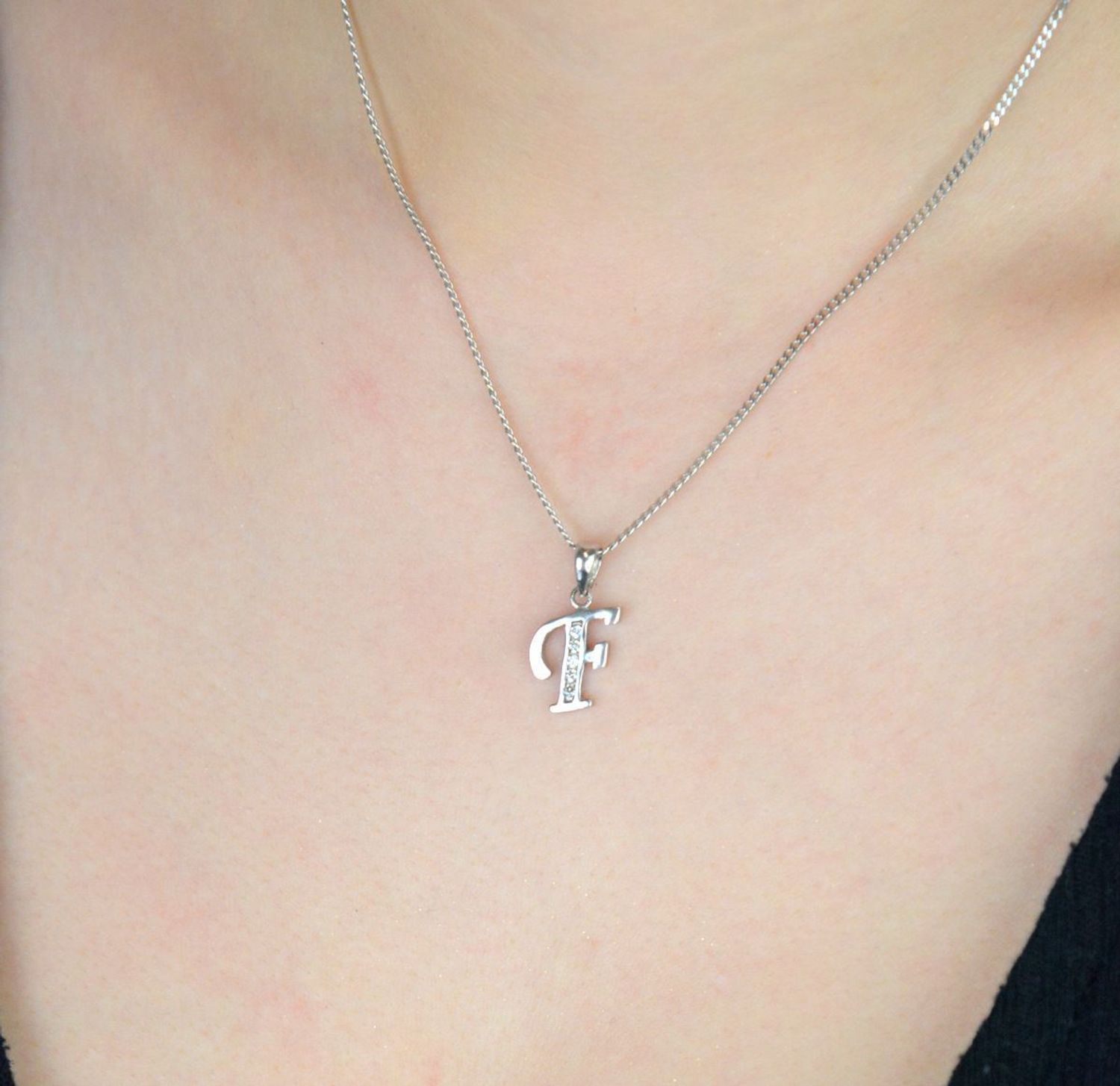 Elegancka srebrna zawieszka z literką F zdobioną cyrkoniami. Próba 925, waga 0,90 g, długość 2 cm, szerokość 0,9 cm. Subtelny blask i osobisty symbol w jednym..jpg