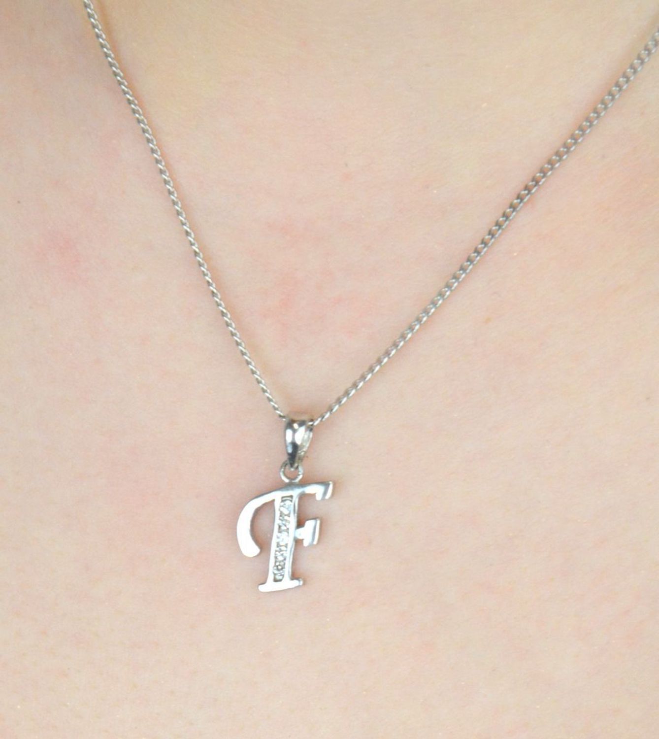 Elegancka srebrna zawieszka z literką F zdobioną cyrkoniami. Próba 925, waga 0,90 g, długość 2 cm, szerokość 0,9 cm. Subtelny blask i osobisty symbol w jednym..jpg