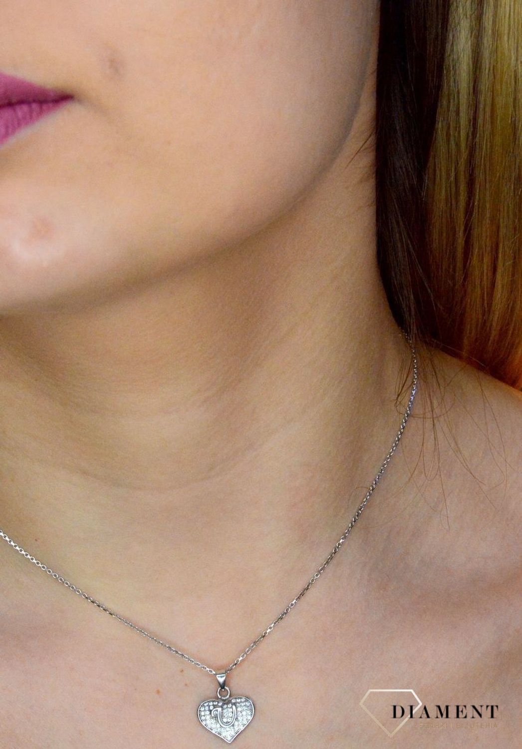 Srebrna zawieszka literka U w serduszku z cyrkoniami DIA-ZAW-8752-U-925. Zawieszka w kształcie serduszka z literką U w środku wykonana z najwyższej próby srebra. Srebrna zawieszka w kształcie serca wykonana została w próby 925.jpg