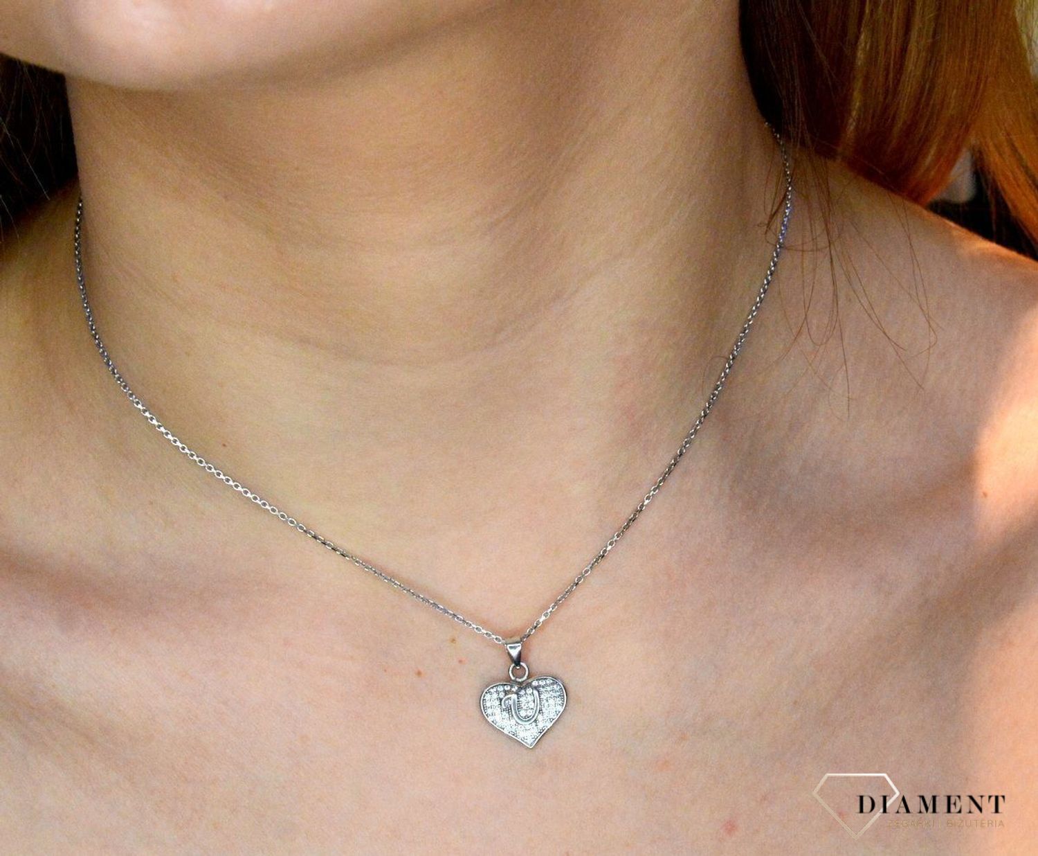 Srebrna zawieszka literka U w serduszku z cyrkoniami DIA-ZAW-8752-U-925. Zawieszka w kształcie serduszka z literką U w środku wykonana z najwyższej próby srebra. Srebrna zawieszka w kształcie serca wykonana została w próby 925.jpg