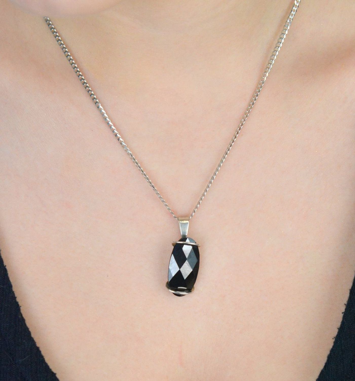 Elegancka zawieszka damska ze srebra próby 925, ozdobiona dużym owalnym czarnym kryształem. Waga 5,60 g, szerokość 1,3 cm, długość 3,0 cm. Idealna do wieczorowych stylizacji..jpg