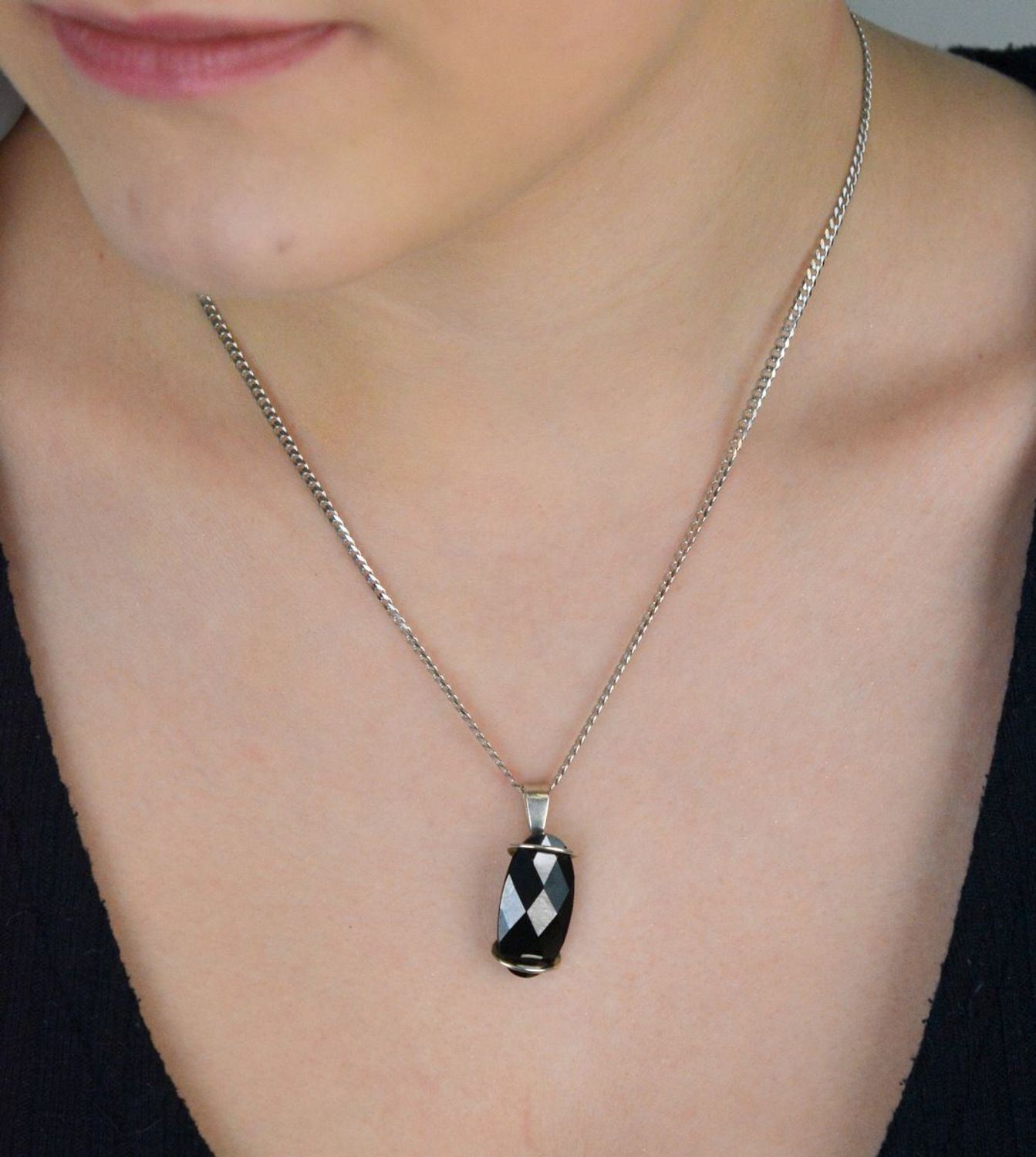 Elegancka zawieszka damska ze srebra próby 925, ozdobiona dużym owalnym czarnym kryształem. Waga 5,60 g, szerokość 1,3 cm, długość 3,0 cm. Idealna do wieczorowych stylizacji..jpg