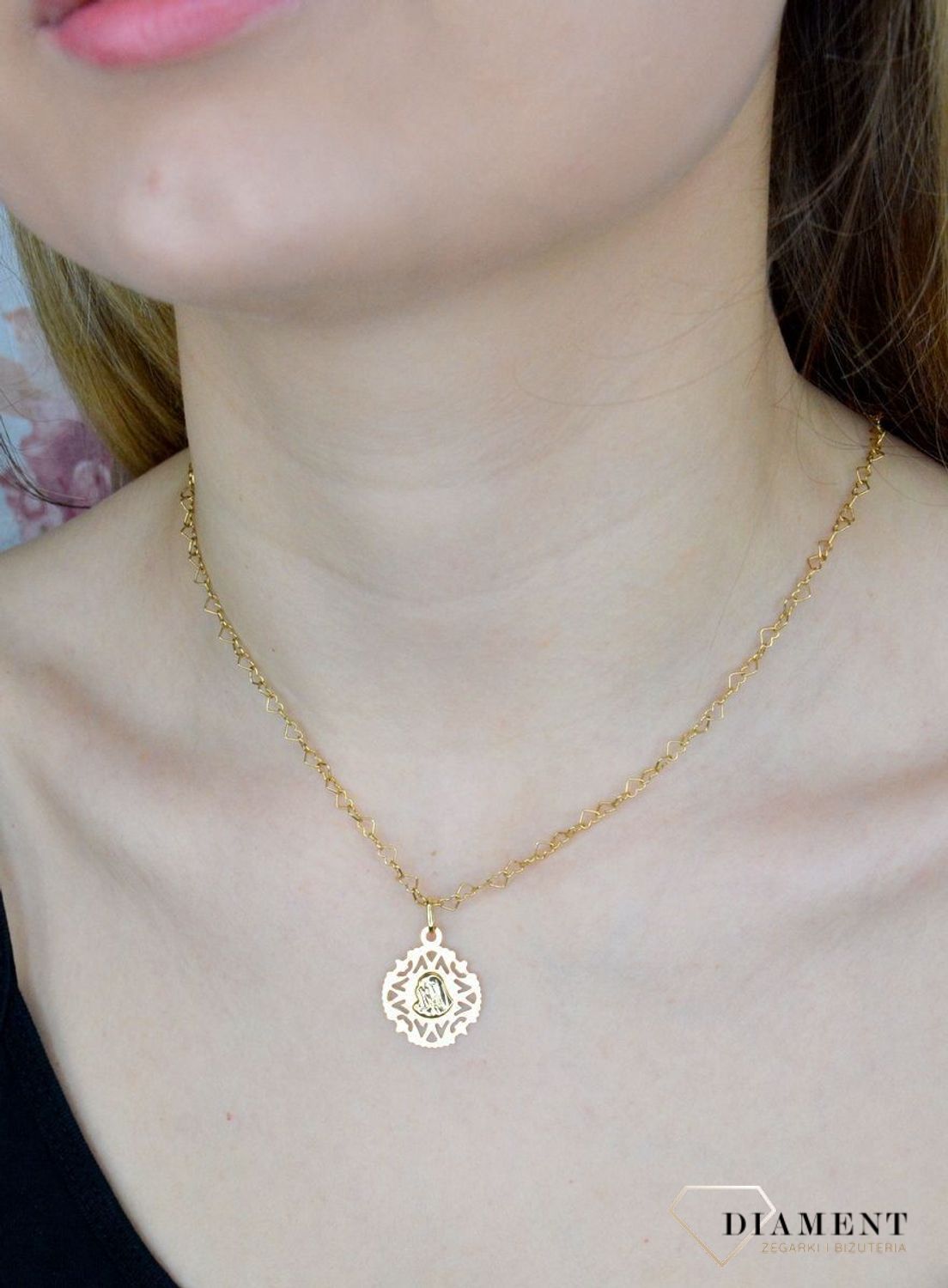 Złota zawieszka 585 medalik z Matką Boską DIA-ZAW-9010-585. Piękny medalik o bogatej symbolice religijnej. Sakralną biżuterię wykonano z 14-karatowego żółtego złota, kruszcu od wielu setek lat symbolizującego doskonałość i pon.jpg