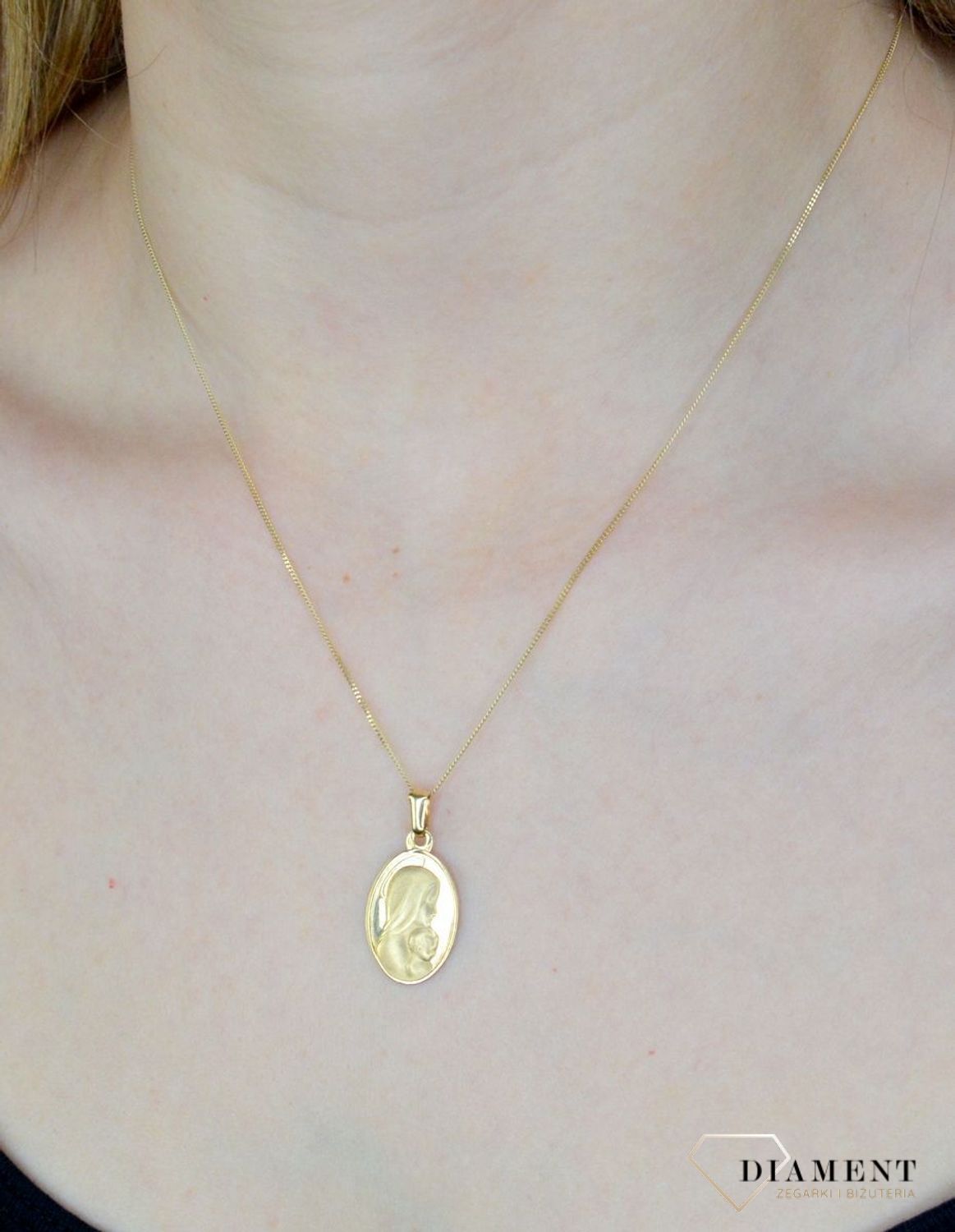 Złota zawieszka 585 owalny medalik z Matką Boską DIA-ZAW-9024-585. Medalik będący wspaniałą pamiątką i prezentem z okazji chrztu, komunii czy bierzmowania. Zawieszka wykonana ze złota próby 585 Piękna biżuteria o bogatej symbo.jpg