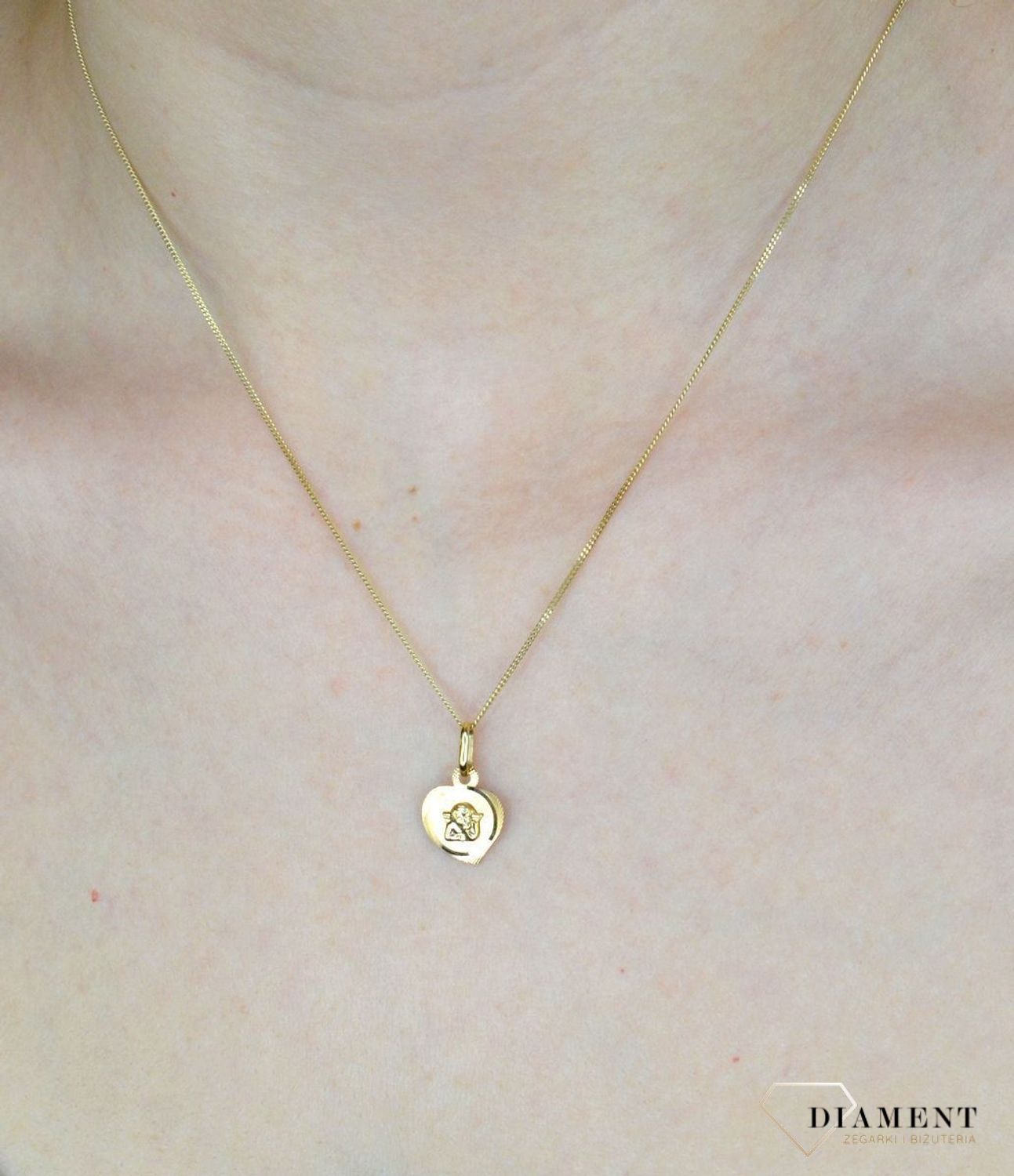 Złota zawieszka 585 medalik aniołek w serduszku DIA-ZAW-9027-585. Złota zawieszka 585 medalik aniołek w serduszku. Medalik będący wspaniałą pamiątką i prezentem z okazji chrztu, komunii czy bierzmowania. Zawieszka wykonana ze.jpg