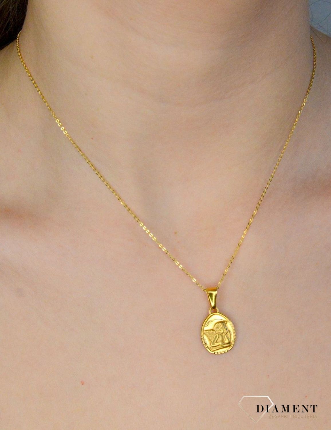 Złota zawieszka 333 medalik z Aniołkiem DIA-ZAW-9123-333 .Złota zawieszka medalik o owalnym kształcie z wizerunkiem śpiącego aniołka. Zawieszka o wielkości 1,7 cm.jpg