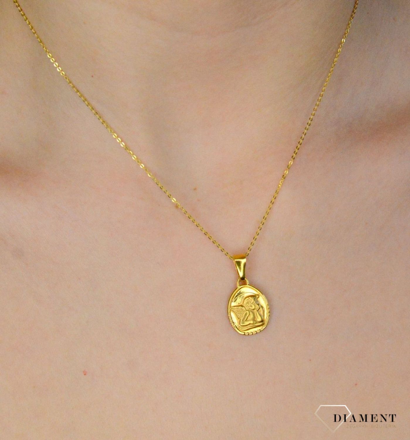 Złota zawieszka 333 medalik z Aniołkiem DIA-ZAW-9123-333 .Złota zawieszka medalik o owalnym kształcie z wizerunkiem śpiącego aniołka. Zawieszka o wielkości 1,7 cm.jpg