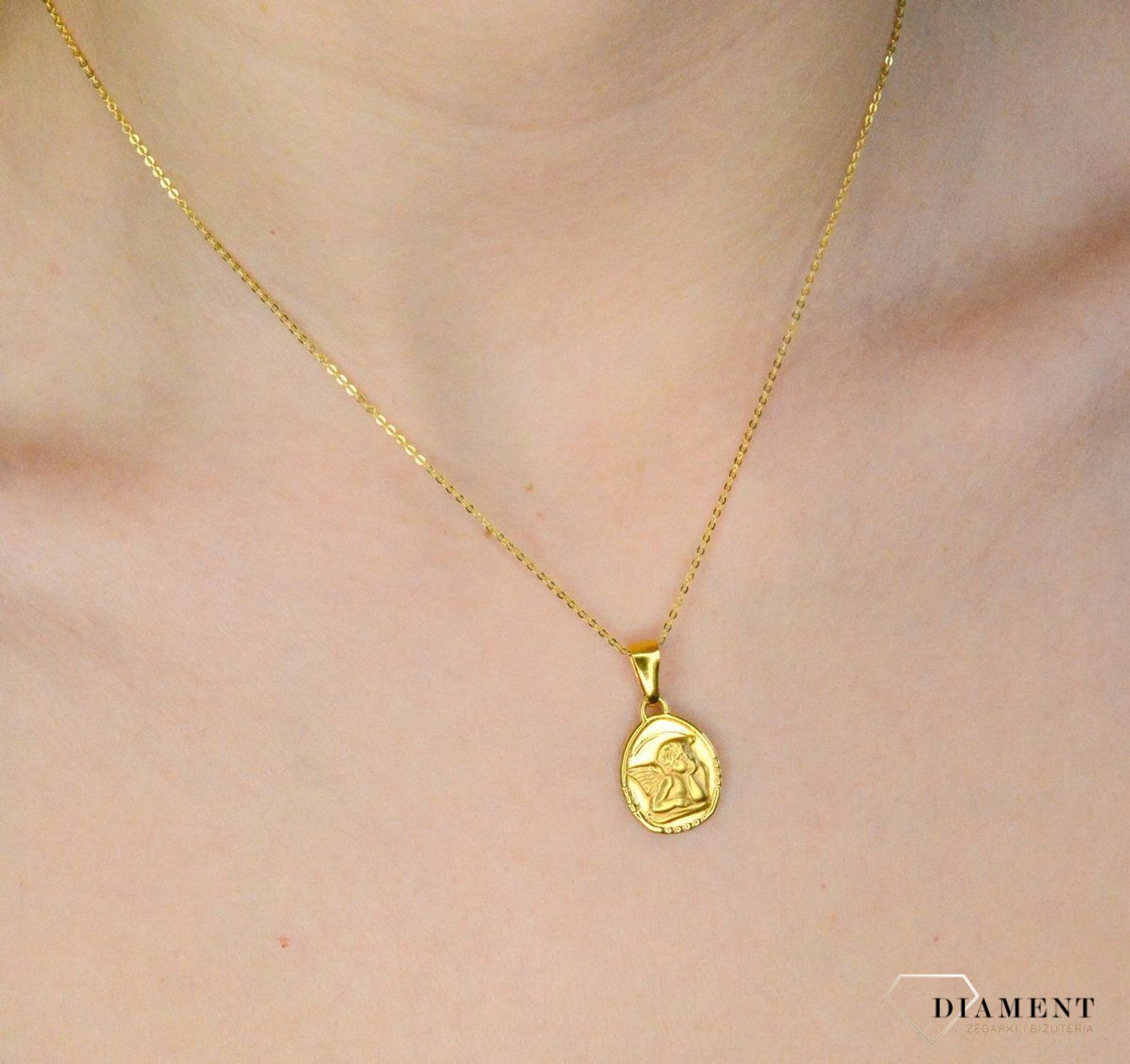 Złota zawieszka 333 medalik z Aniołkiem DIA-ZAW-9123-333 .Złota zawieszka medalik o owalnym kształcie z wizerunkiem śpiącego aniołka. Zawieszka o wielkości 1,7 cm.jpg