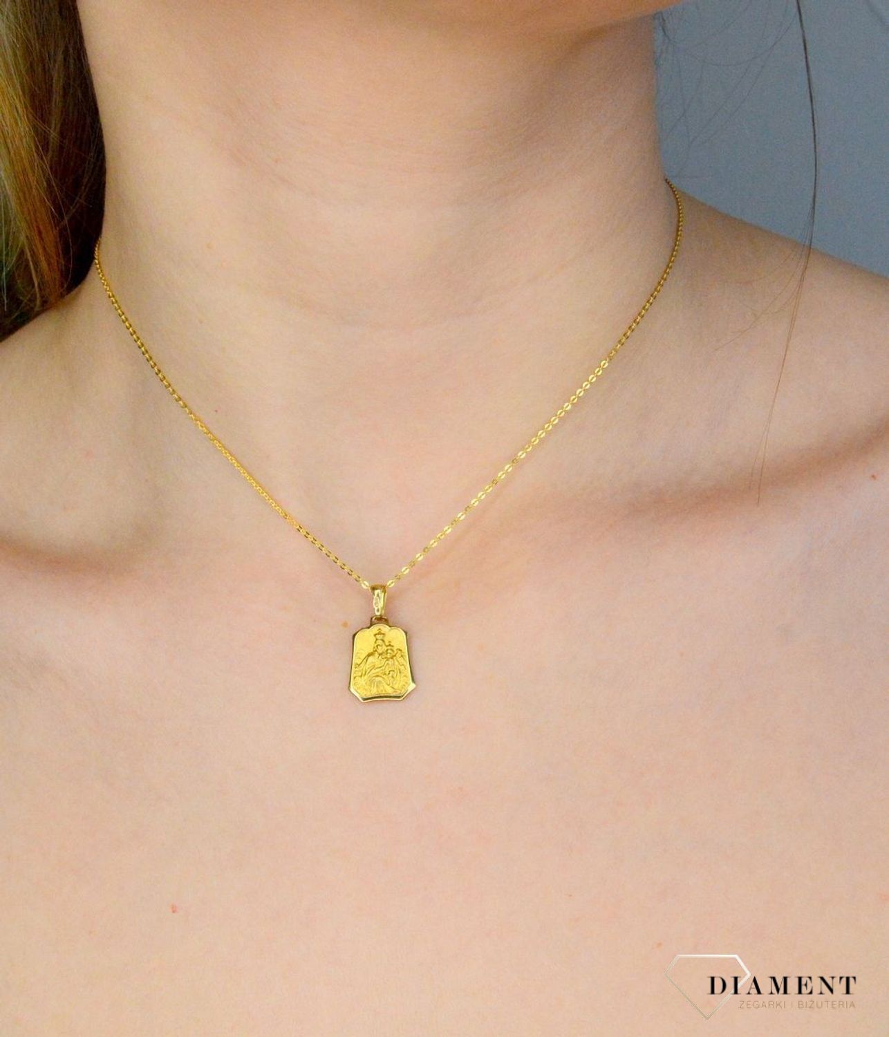 Złota zawieszka 333 medalik Szkaplerz DIA-ZAW-9128-333. Medalik będący wspaniałą pamiątką i prezentem z okazji chrztu, komunii czy bierzmowania. Zawieszka wykonana ze złota próby 333. Szkaplerz medalik złoty. Złoty medalik szk.jpg
