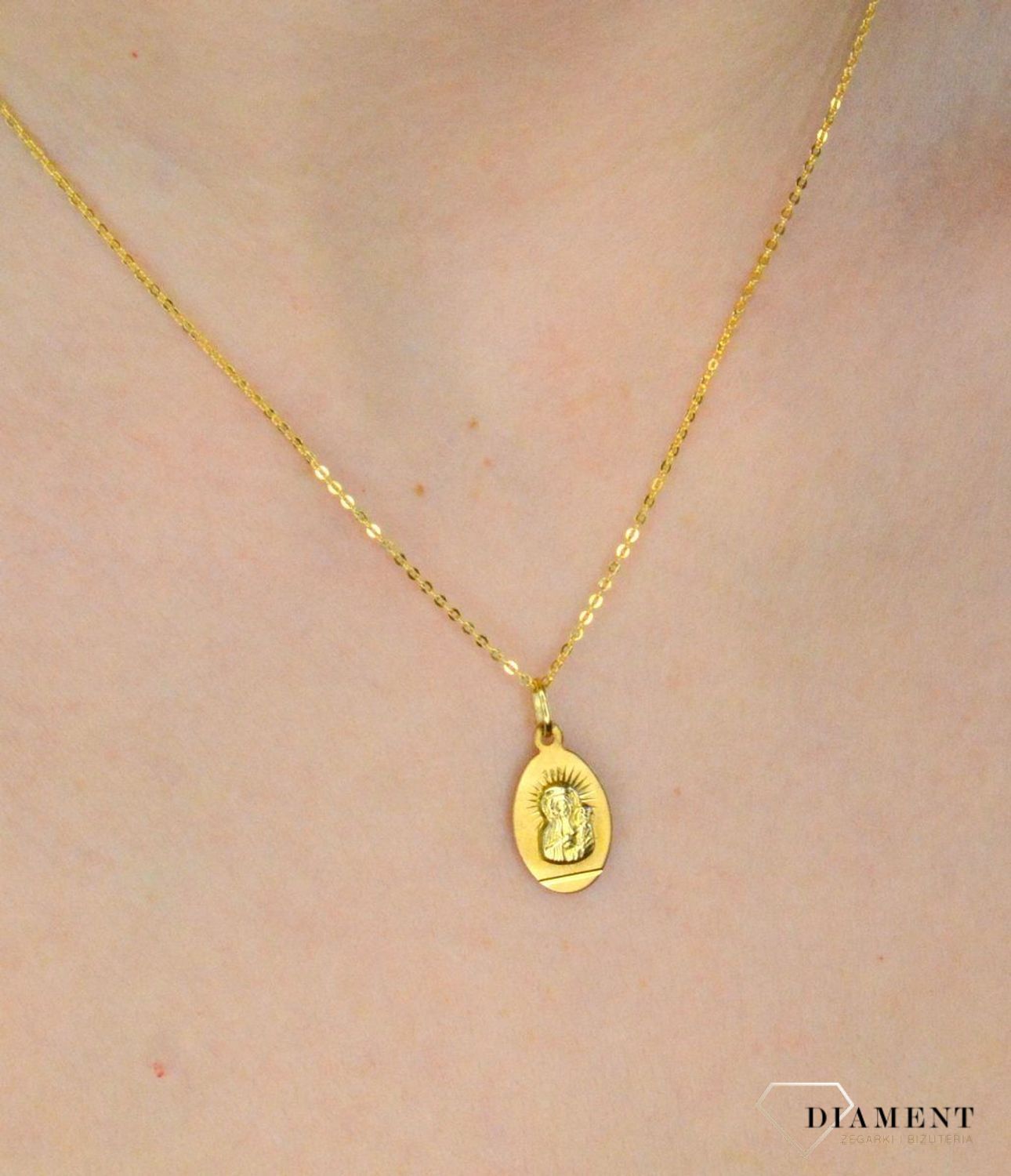 Złota zawieszka 333 medalik z Matką Boską DIA-ZAW-9130-333. Medalik będący wspaniałą pamiątką i prezentem z okazji chrztu, komunii czy bierzmowania. Zawieszka wykonana ze złota próby 333.  (1).jpg