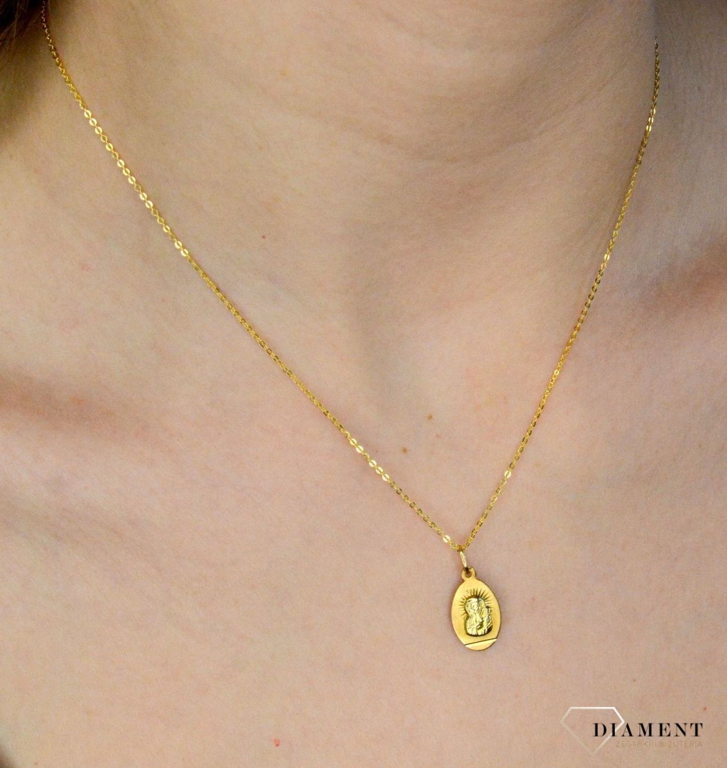 Złota zawieszka 333 medalik z Matką Boską DIA-ZAW-9130-333. Medalik będący wspaniałą pamiątką i prezentem z okazji chrztu, komunii czy bierzmowania. Zawieszka wykonana ze złota próby 333.  (1).jpg
