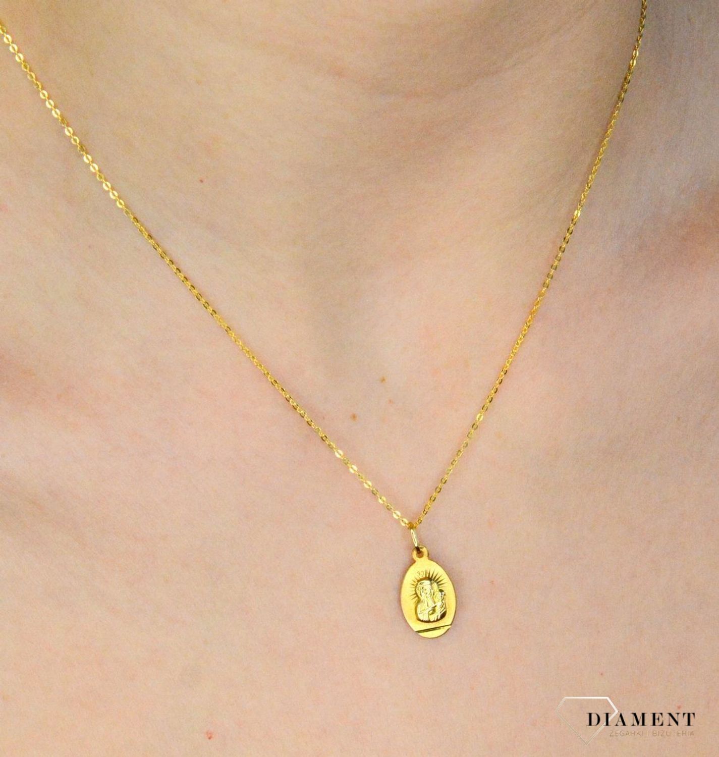 Złota zawieszka 333 medalik z Matką Boską DIA-ZAW-9130-333. Medalik będący wspaniałą pamiątką i prezentem z okazji chrztu, komunii czy bierzmowania. Zawieszka wykonana ze złota próby 333.  (1).jpg