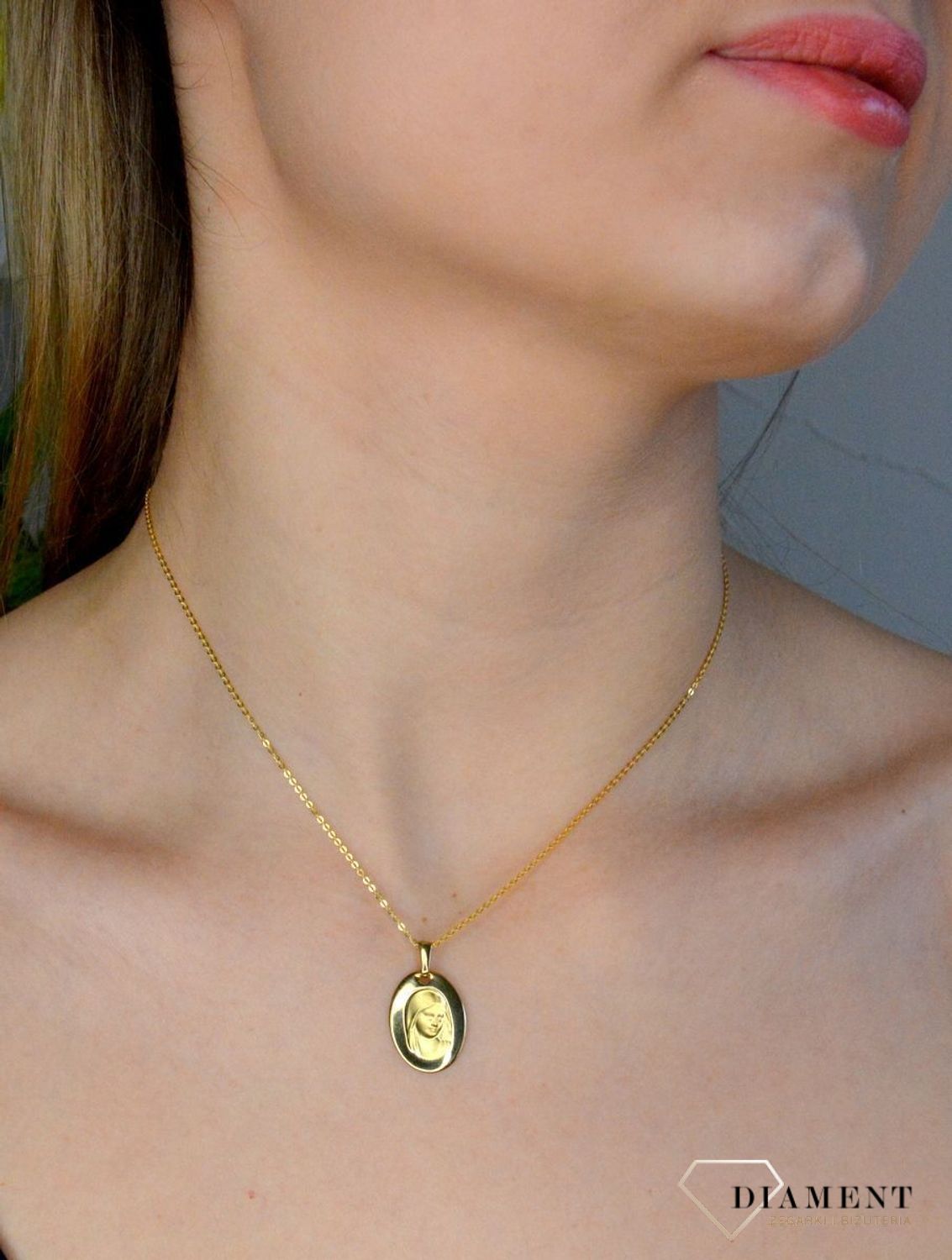 Złota zawieszka 333 medalik z Matką Boską DIA-ZAW-9133-333. Medalik będący wspaniałą pamiątką i prezentem z okazji chrztu, komunii czy bierzmowania. Zawieszka wykonana ze złota próby 333..jpg