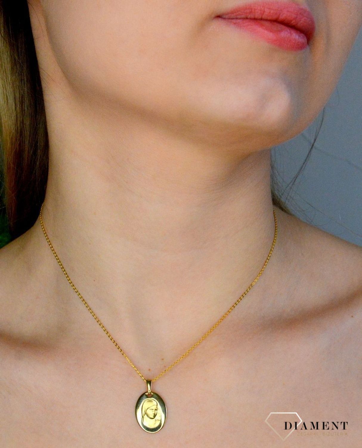 Złota zawieszka 333 medalik z Matką Boską DIA-ZAW-9133-333. Medalik będący wspaniałą pamiątką i prezentem z okazji chrztu, komunii czy bierzmowania. Zawieszka wykonana ze złota próby 333..jpg