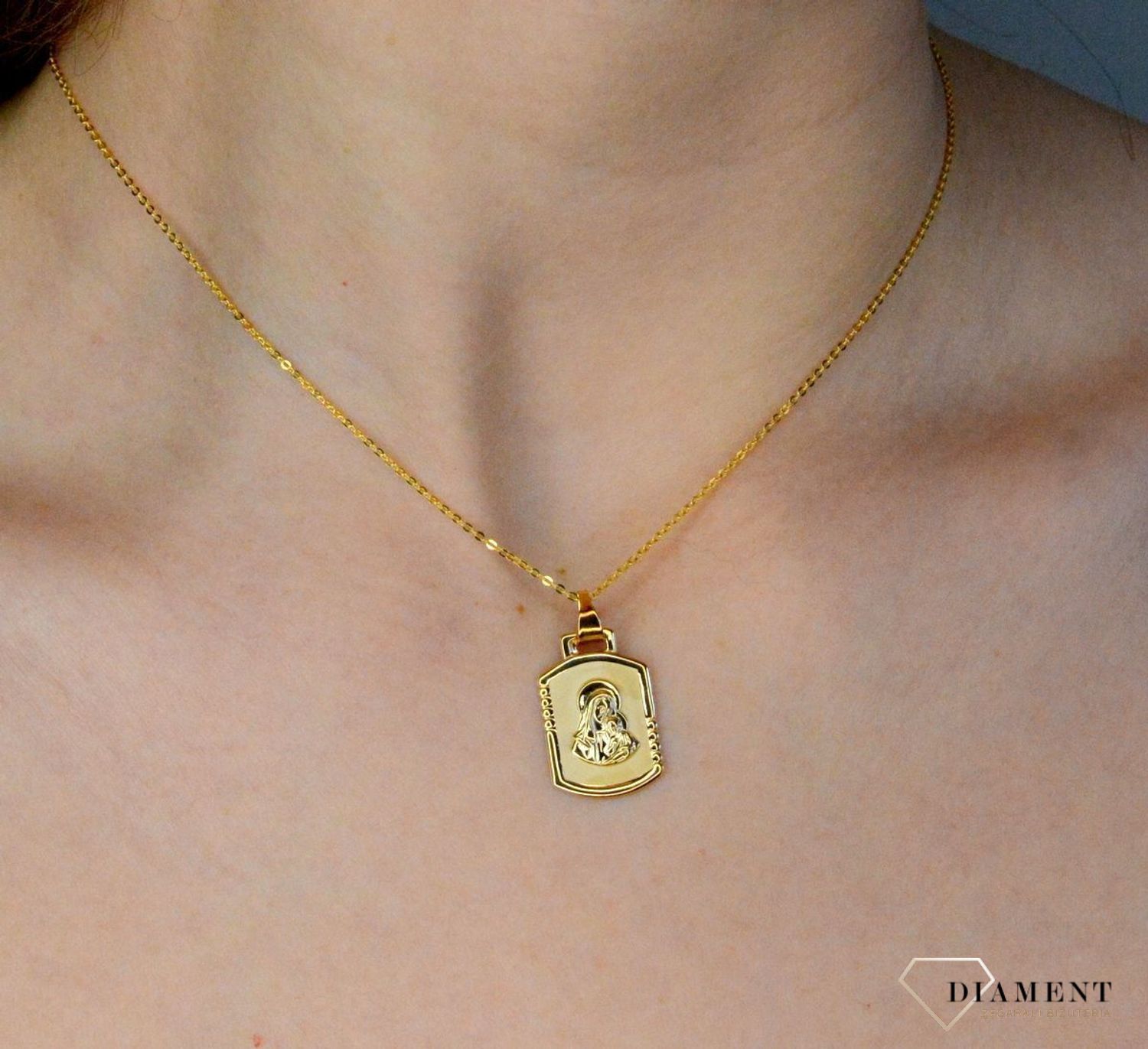 Złota zawieszka 333 medalik Matka Boska z dzieciątkiem DIA-ZAW-9137-333. Medalik będący wspaniałą pamiątką i prezentem z okazji chrztu, komunii czy bierzmowania. Zawieszka wykonana ze złota próby 333..jpg