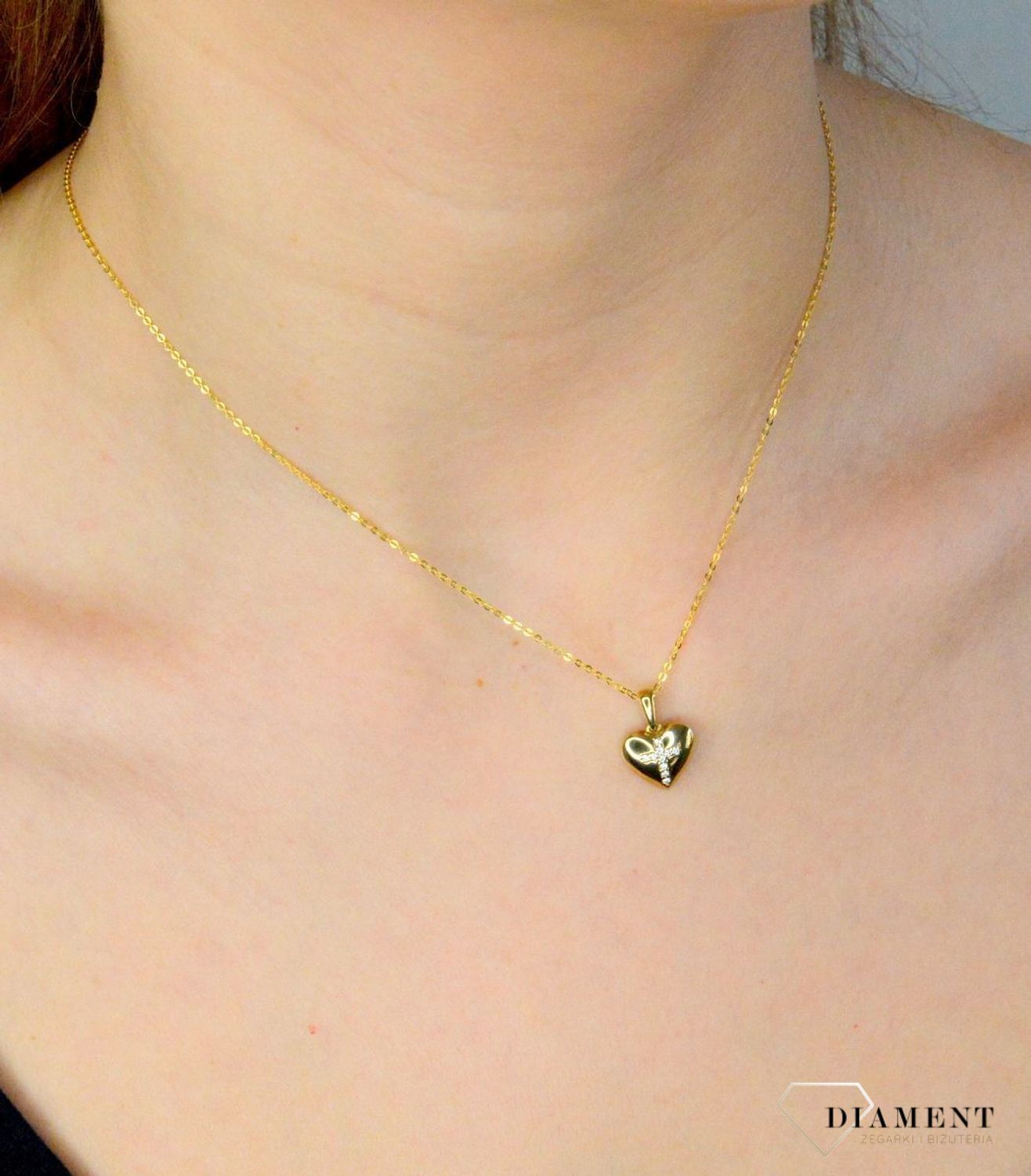 Złota zawieszka 333 serce z krzyżykiem z cyrkonii DIA-ZAW-9138-333. Zawieszka w kształcie serca z krzyżykiem będzie wspaniałą pamiątką i prezentem z okazji chrztu, komunii czy bierzmowania. Zawieszka wykonana ze złota próby 33.jpg