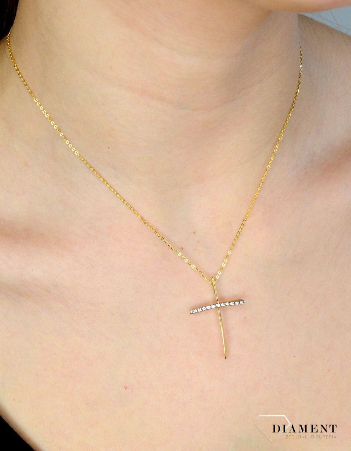 Złota zawieszka krzyżyk 333 z cyrkoniami DIA-ZAW-9141-333. Piękna zawieszka krzyżyk wykonana z żółtego złota, wysokiej próby 333. Krzyżyk jest ozdobiony cyrkoniami, co daje bardzo ładny, ciekawy efekt. Zawieszka złota krzyżyk.jpg