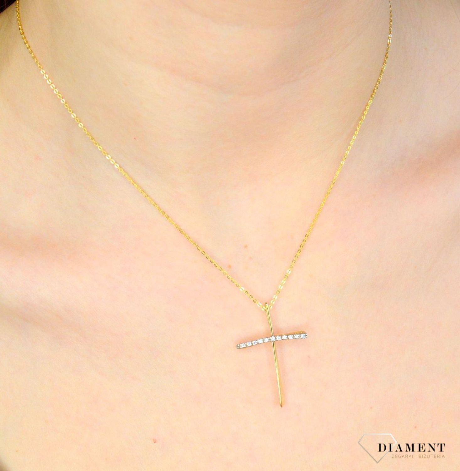 Złota zawieszka krzyżyk 333 z cyrkoniami DIA-ZAW-9141-333. Piękna zawieszka krzyżyk wykonana z żółtego złota, wysokiej próby 333. Krzyżyk jest ozdobiony cyrkoniami, co daje bardzo ładny, ciekawy efekt. Zawieszka złota krzyżyk.jpg
