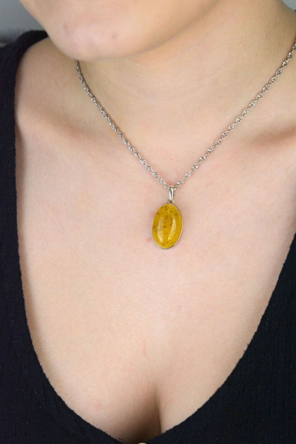 Srebrna zawieszka damska z piaskowym bursztynem o owalnym kształcie DIA-ZAW-9906-925. Srebrna zawieszka damska. Srebrna zawieszka idealna na prezent. Zawieszka damska z kamieniem. Zawieszka srebrna damska z bursztynem bałtycki.jpg