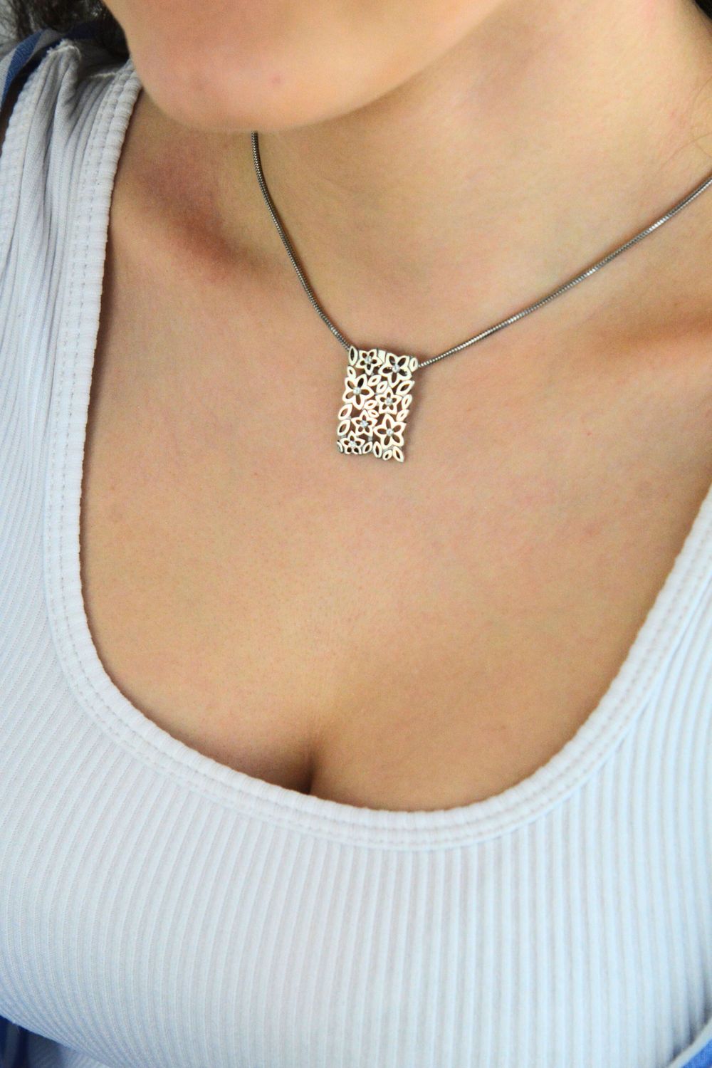 Elegancka srebrna zawieszka damska w kształcie prostokąta, zdobiona drobnymi kwiatkami i cyrkoniami. Wykonana ze srebra próby 925 o wadze 2,97 g. Idealna na prezent.1.jpg