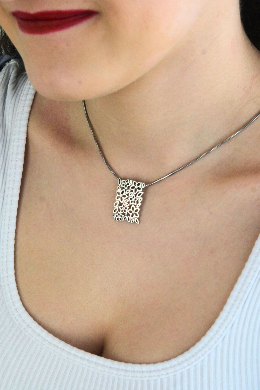 Elegancka srebrna zawieszka damska w kształcie prostokąta, zdobiona drobnymi kwiatkami i cyrkoniami. Wykonana ze srebra próby 925 o wadze 2,97 g. Idealna na prezent.1.jpg