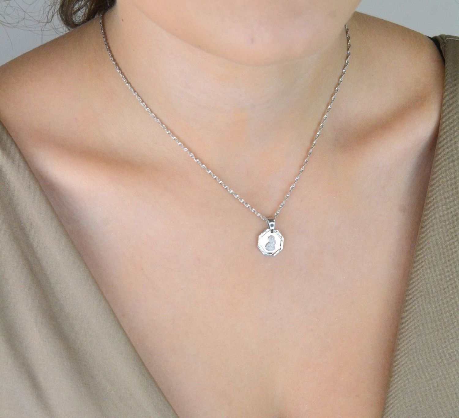 Srebrna zawieszka – medalik z Matką Boską i Dzieciątkiem, wykonana ze srebra próby 925. Klasyczny wzór o wymiarach 1,7 x 1,2 cm. Model DIA-ZAW-GMD152R-925 – symbol wiary i ochrony.1.jpg