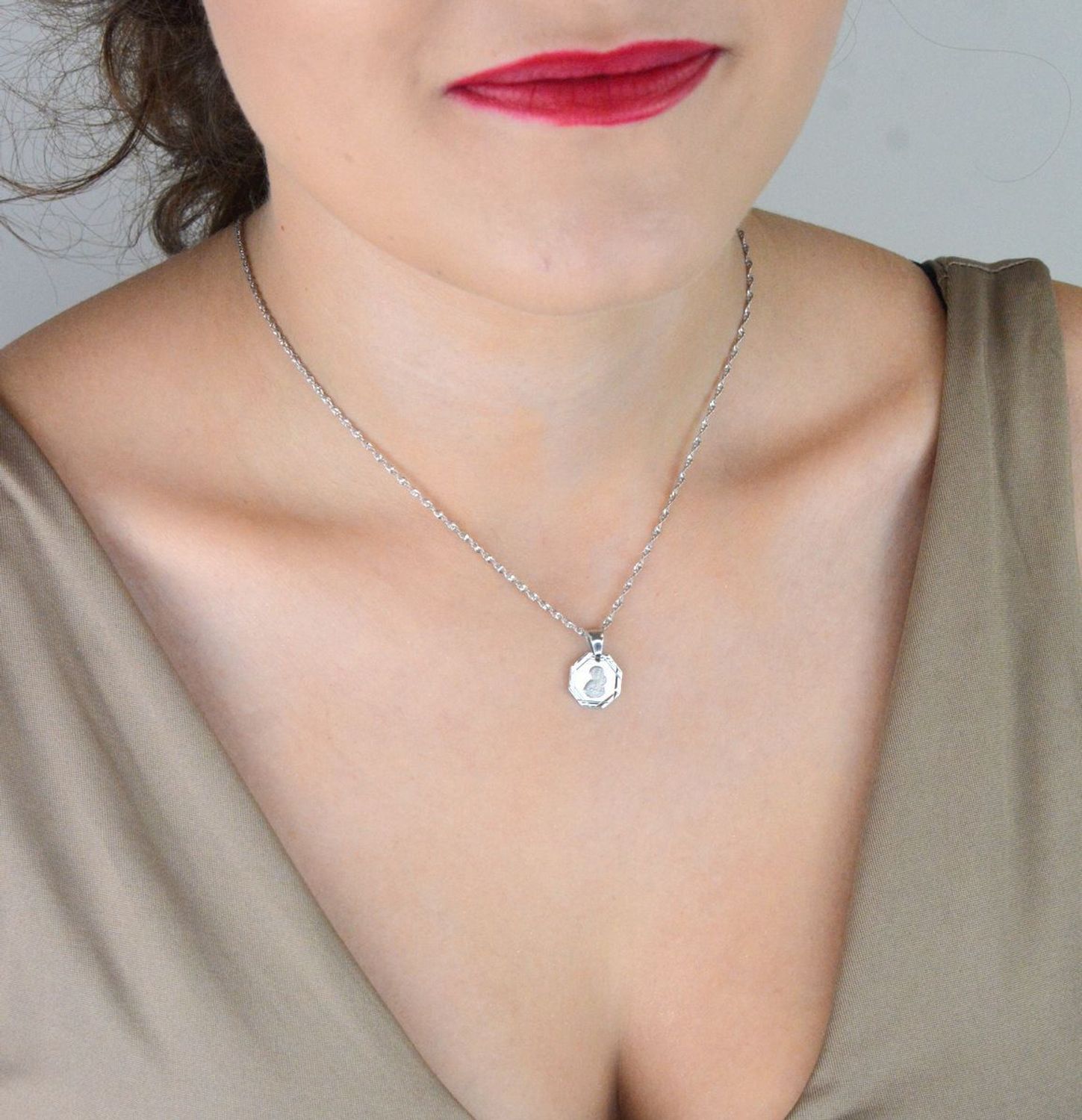 Srebrna zawieszka – medalik z Matką Boską i Dzieciątkiem, wykonana ze srebra próby 925. Klasyczny wzór o wymiarach 1,7 x 1,2 cm. Model DIA-ZAW-GMD152R-925 – symbol wiary i ochrony.1.jpg