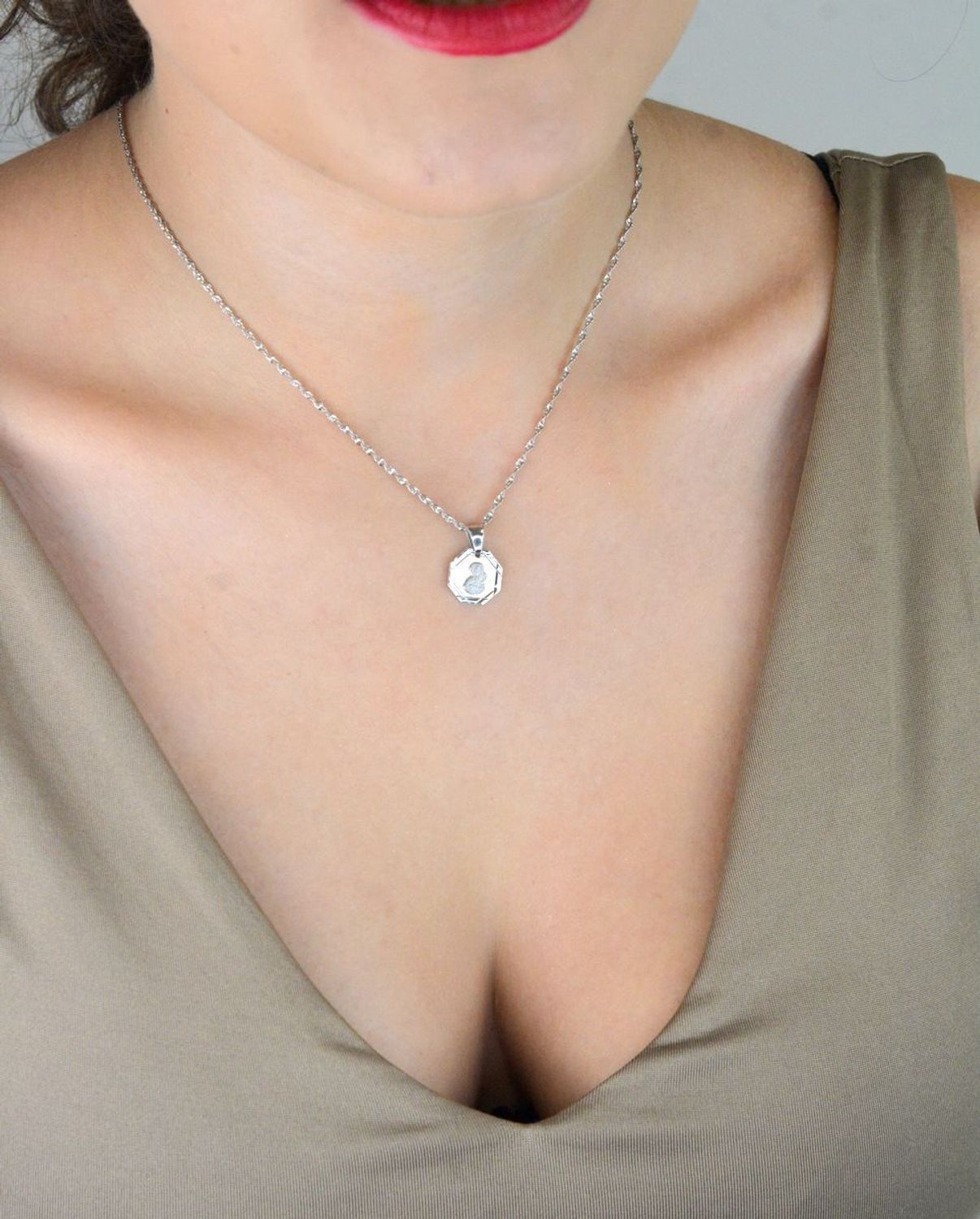 Srebrna zawieszka – medalik z Matką Boską i Dzieciątkiem, wykonana ze srebra próby 925. Klasyczny wzór o wymiarach 1,7 x 1,2 cm. Model DIA-ZAW-GMD152R-925 – symbol wiary i ochrony.1.jpg