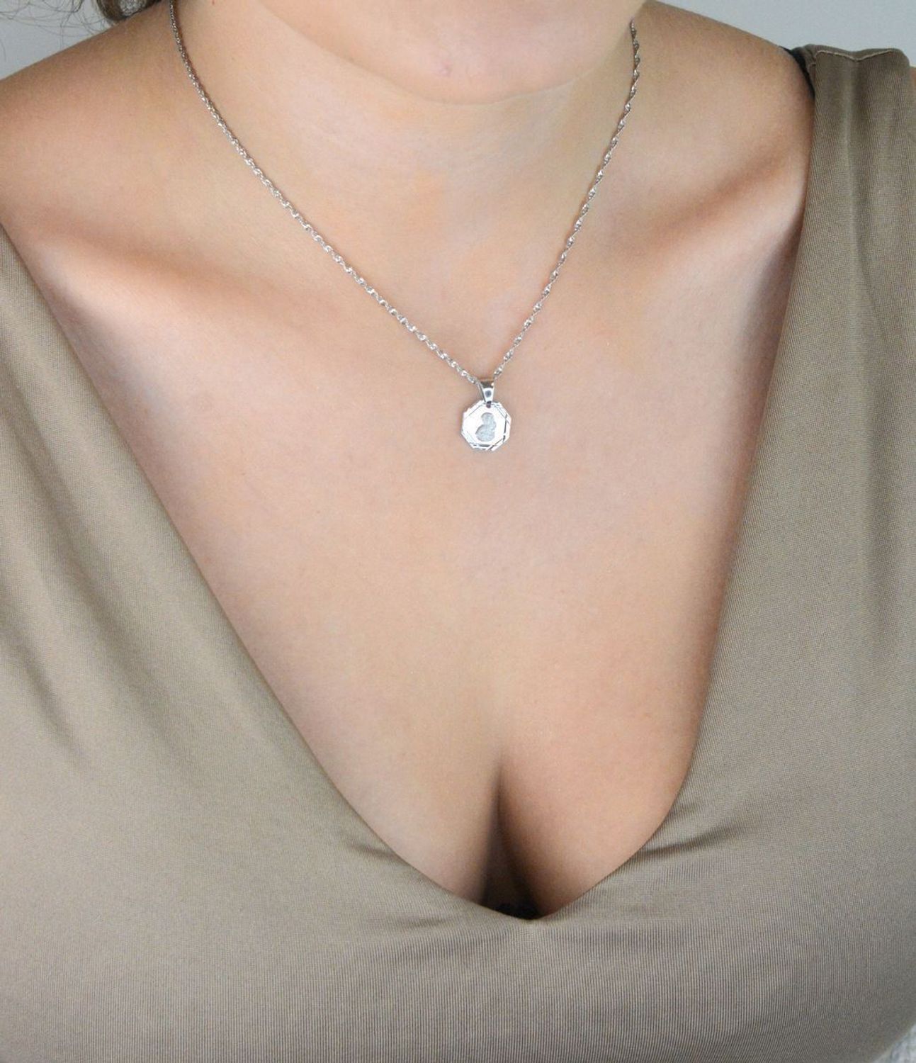 Srebrna zawieszka – medalik z Matką Boską i Dzieciątkiem, wykonana ze srebra próby 925. Klasyczny wzór o wymiarach 1,7 x 1,2 cm. Model DIA-ZAW-GMD152R-925 – symbol wiary i ochrony.1.jpg