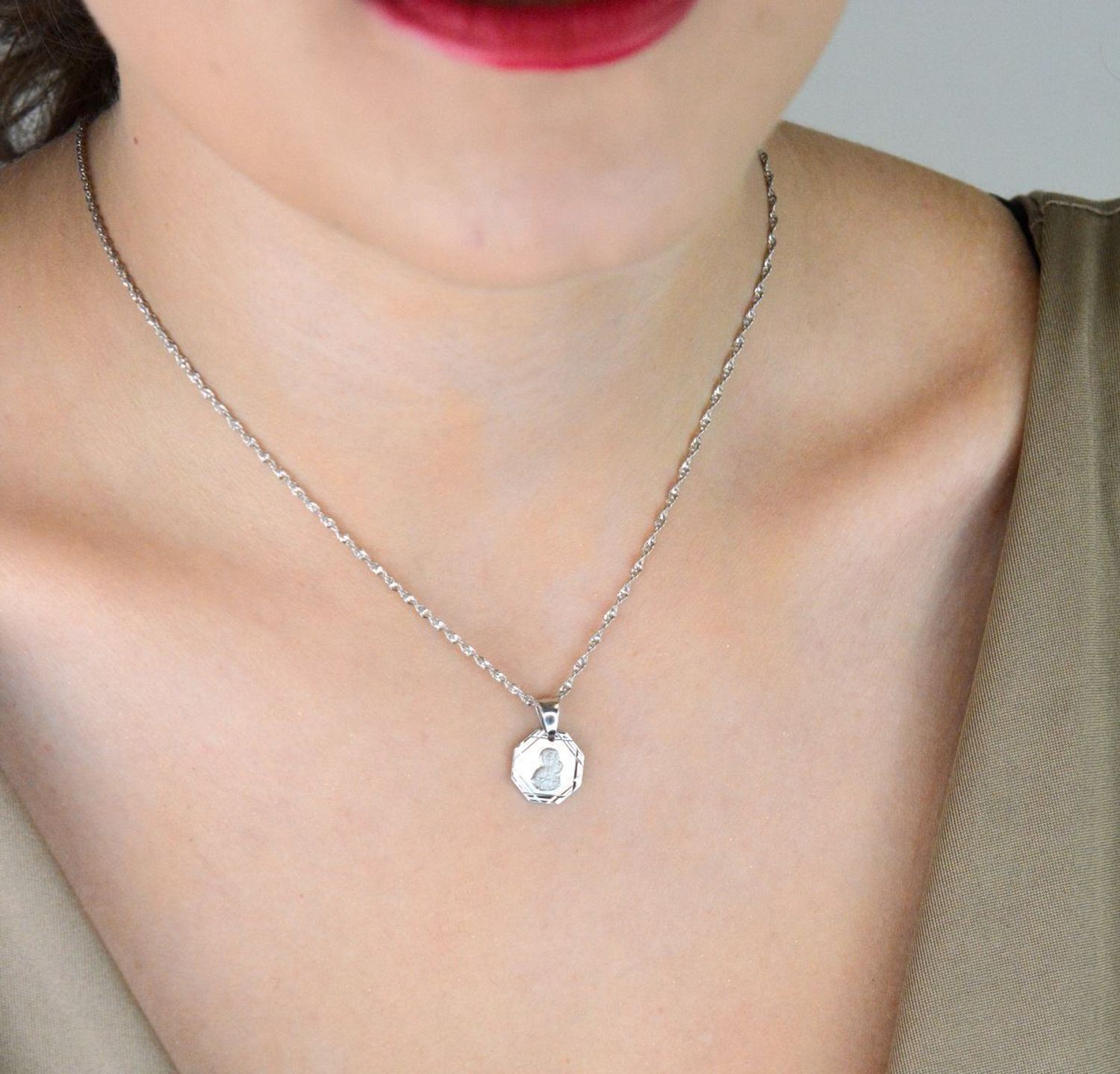 Srebrna zawieszka – medalik z Matką Boską i Dzieciątkiem, wykonana ze srebra próby 925. Klasyczny wzór o wymiarach 1,7 x 1,2 cm. Model DIA-ZAW-GMD152R-925 – symbol wiary i ochrony.1.jpg